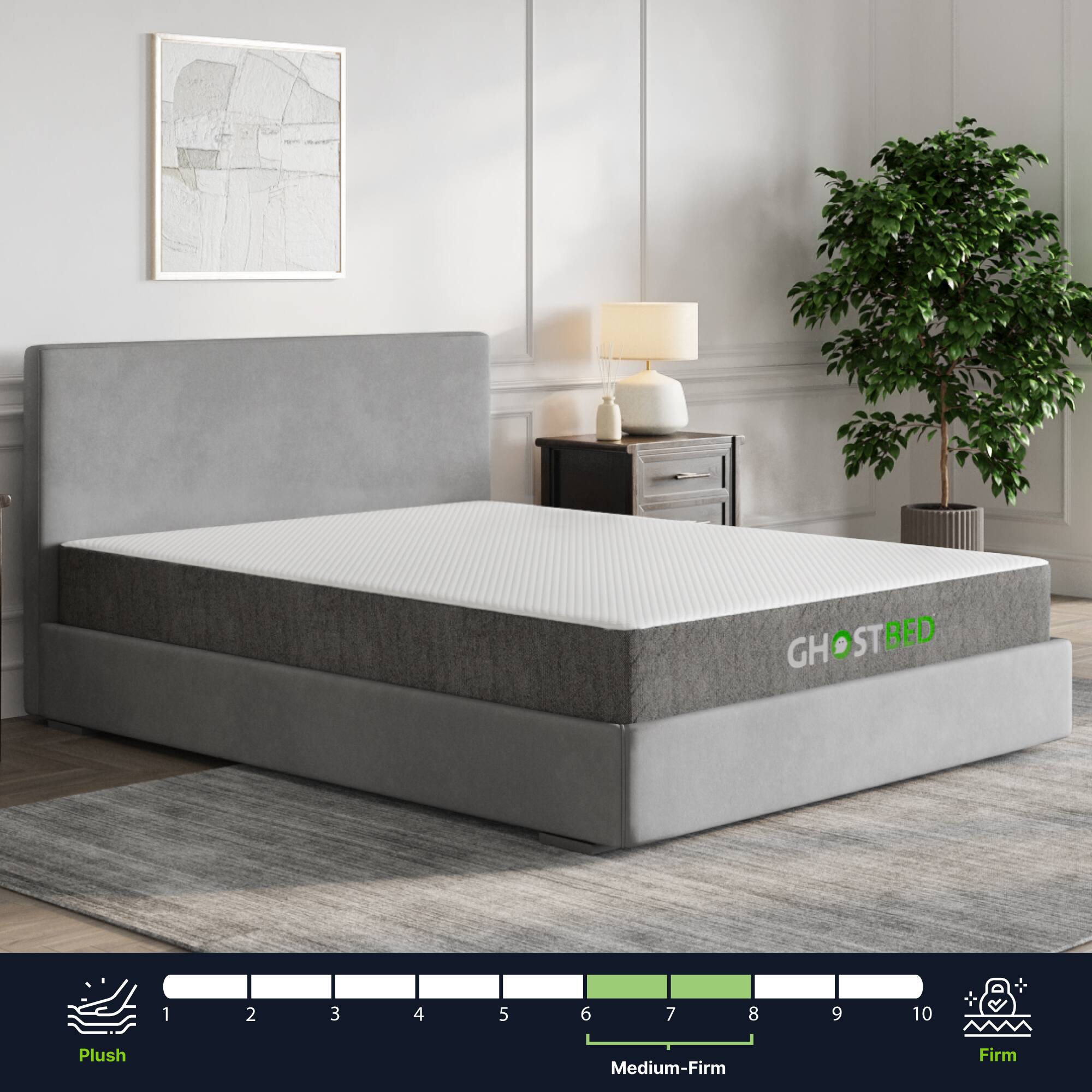 The image features a bed with a gray mattress and a white frame. The mattress is a medium-firm level, and the bed is made by Ghostbed. The bed is placed in a room with a potted plant nearby, adding a touch of greenery to the space. The overall scene is clean and well-organized, showcasing the bed as the main focus.