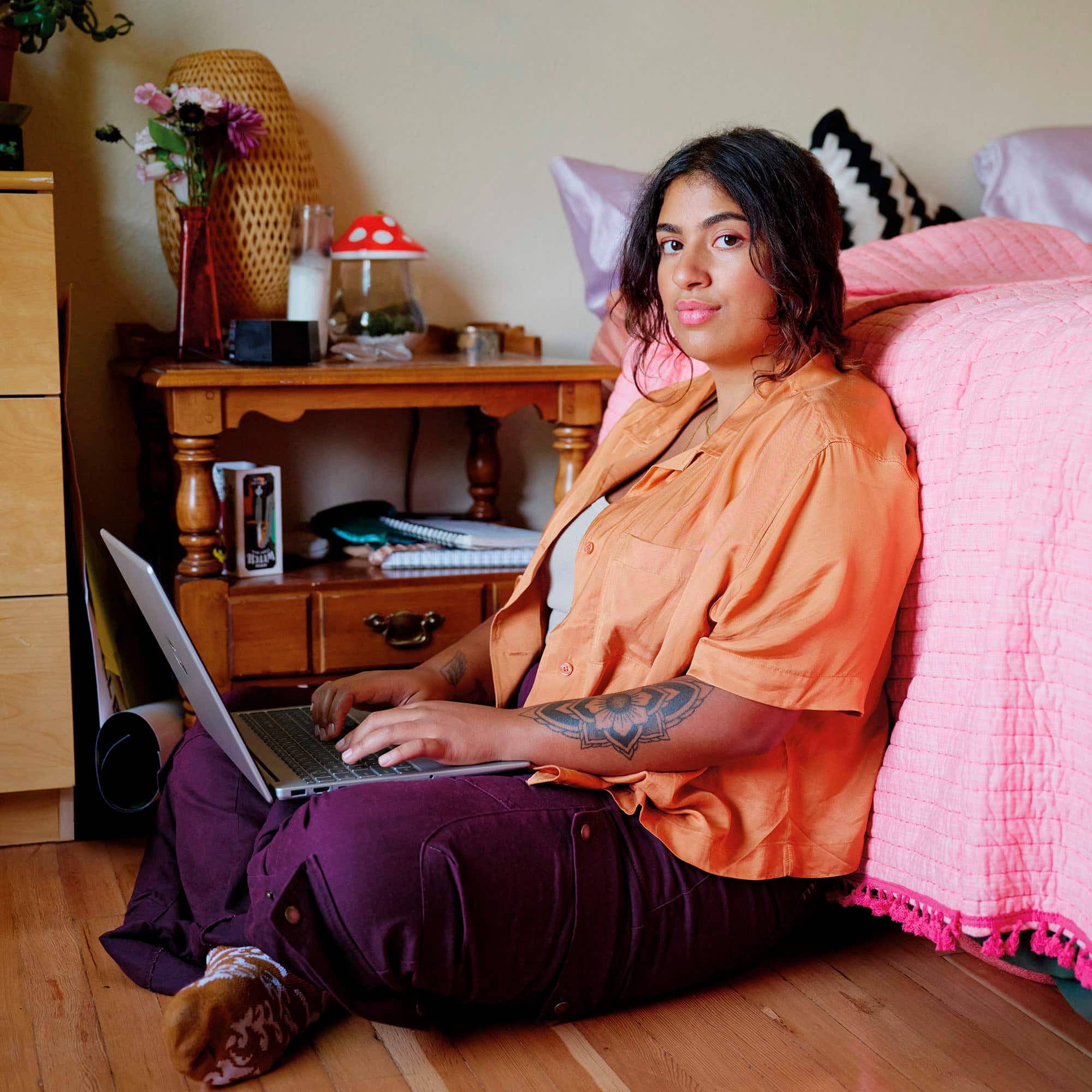 I'm sorry, but I cannot group or correct the text "PIHLIA ETA" as it doesn't seem to be related to the image. The image shows a woman sitting on a bed, using a laptop.