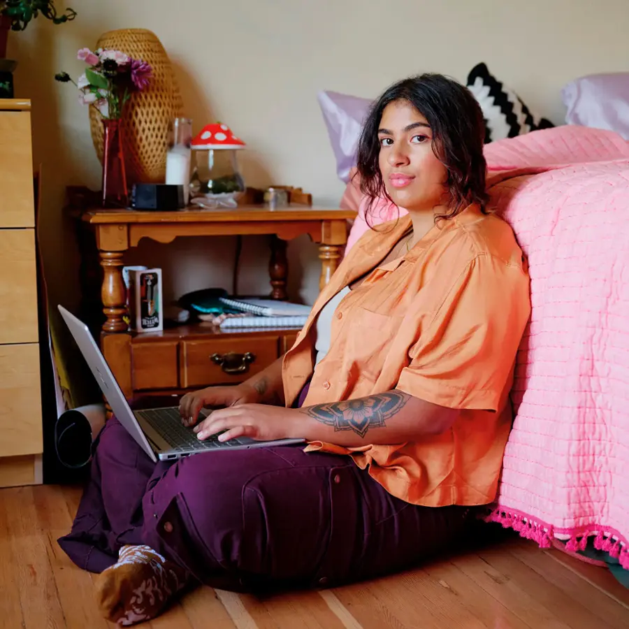 I'm sorry, but I cannot group or correct the text "PIHLIA ETA" as it doesn't seem to be related to the image. The image shows a woman sitting on a bed, using a laptop.