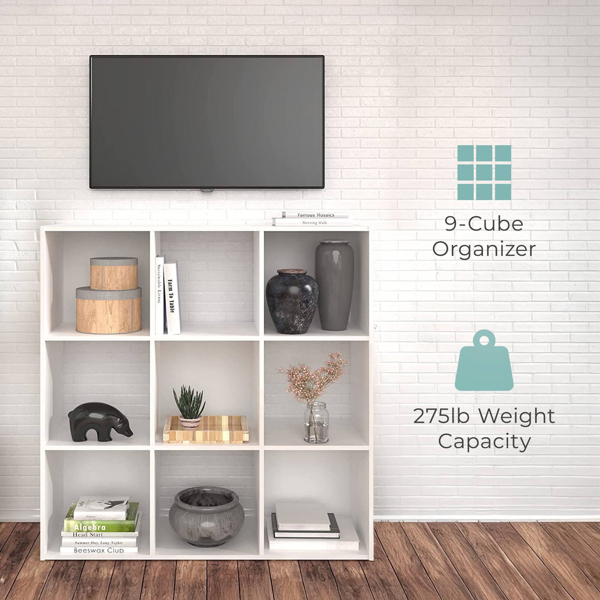 Sure, here is the corrected and grouped text from the image:

---

**9-Cube Organizer**

**275lb Weight Capacity**

---

**Books:**
- "Algebra"
- "Beeswax Club"

**Decorative Items:**
- Vases
- Plant
- Bear figurine
- Wooden tray with plant
- Jars with flowers

**Television:**
- "Famous Mosaics" (on the TV stand)

---