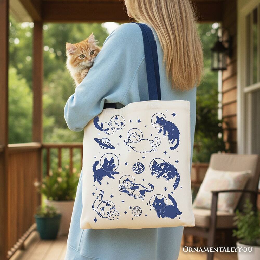 Left. OrnamentallyYou - Cats in Space Retro Canvas Tote Bag, Funny Astronaut Kitty Gift Bag with Cosmic Vibes - White Navy.