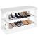 The image shows a white shelf with a variety of shoes on it. There are seven pairs of shoes in total, with some of them being black and white. The shoes are arranged in a neat and organized manner, making the shelf look tidy and visually appealing.