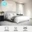 Martha Stewart is the brand behind the bed in the image. The bed features an upholstered curved headboard, a solid wood frame, and legs. It is designed to be used without a box spring, making it a convenient and stylish option for a bedroom.