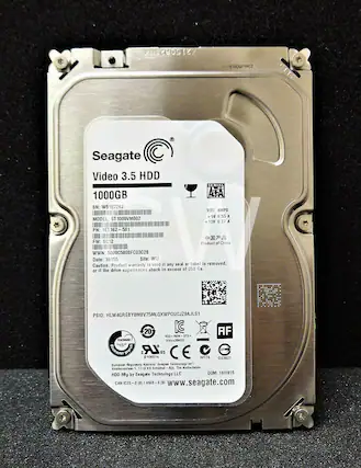 S120ENENK
Seagate Video 3.5 HDD 1000GB
SN: W510726J
MODEL: ST1000VM002
PN: 1ET162-501
SERIAL VDC AMPS
+5V 0.55 A
+12V 0.27 A
FW: SC12
Product of China
WWN: 5000C5008FC03C2B
Date: 16155
Site: WU
Caution. Product warranty is void if any seal or label is removed, if the drive experiences shock in excess of 350 Gs.
PSID: HLW4GREBYOMBV75MLQXWPQUCJZ9AJLS1
20 IC AF CC-RE-STX REM STE- TVHUO
Vide+3SHDD I wud LR US C e 106014 N176 D33027
European Regulatory Address
Seagate Technology
Kooihovenlaan 1, 1119