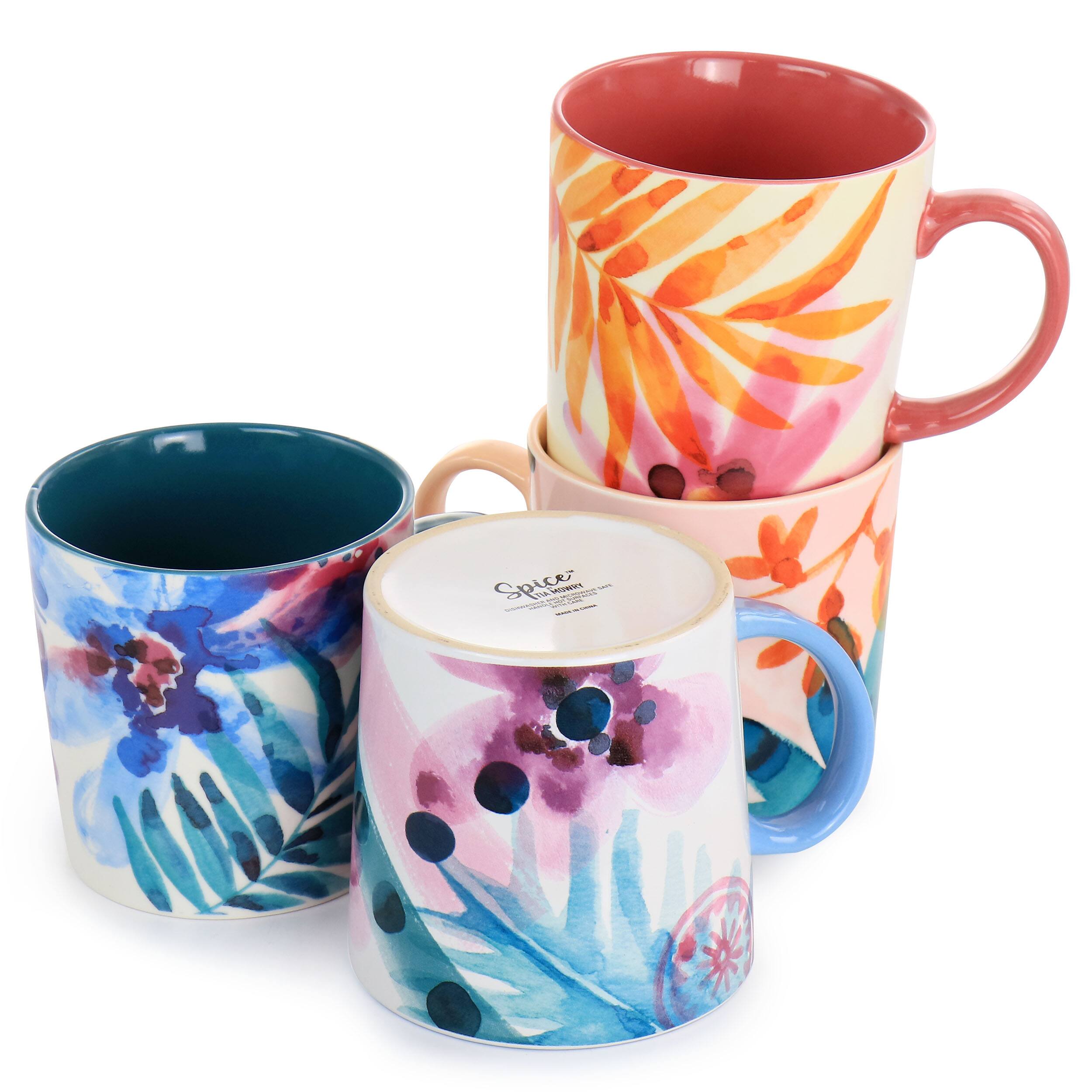 The image shows a group of four coffee mugs, each featuring different designs and colors. They are arranged in a row, with one mug on the left, one in the middle, one on the right, and one at the far end. The mugs are of various sizes, and their designs include floral patterns and other artistic elements. The mugs are placed on a table, creating an appealing display for coffee lovers.