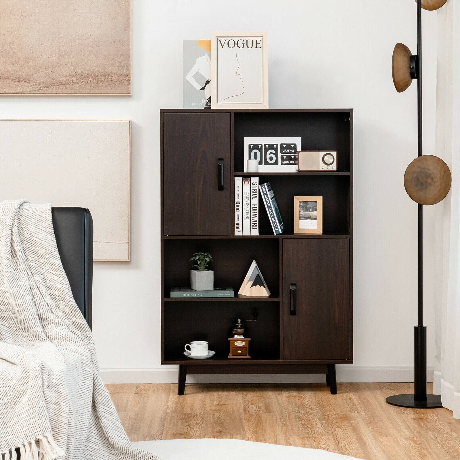 Vogue is a magazine that is displayed on the shelf. The shelf is black and has various items on it, including books and a potted plant. The shelf is located in a living room, and there is a chair nearby.