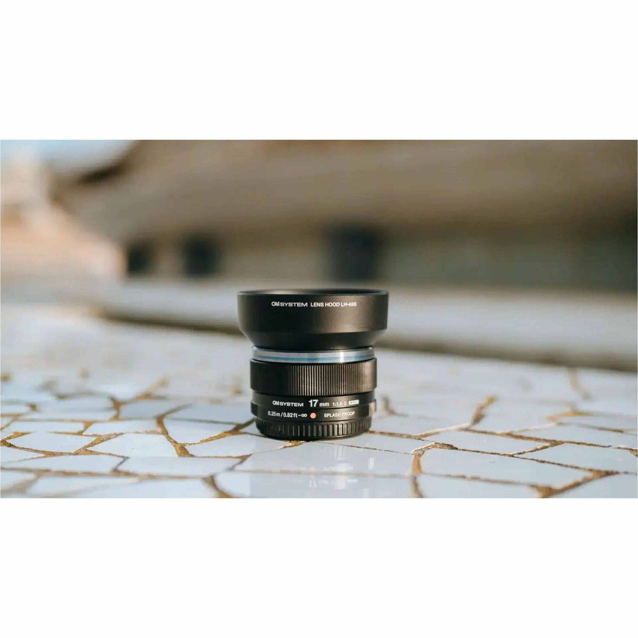 The text on the image reads: "OMBYSYSTEM LENS HOOD UA OMESYSTEM ON BY 17 - 1881 $25m 0.82 -- SPLASPROOF SPLAS ROEP."