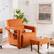 "A cozy living room with an orange chair, a coffee table, a clock on the wall, and a potted plant."