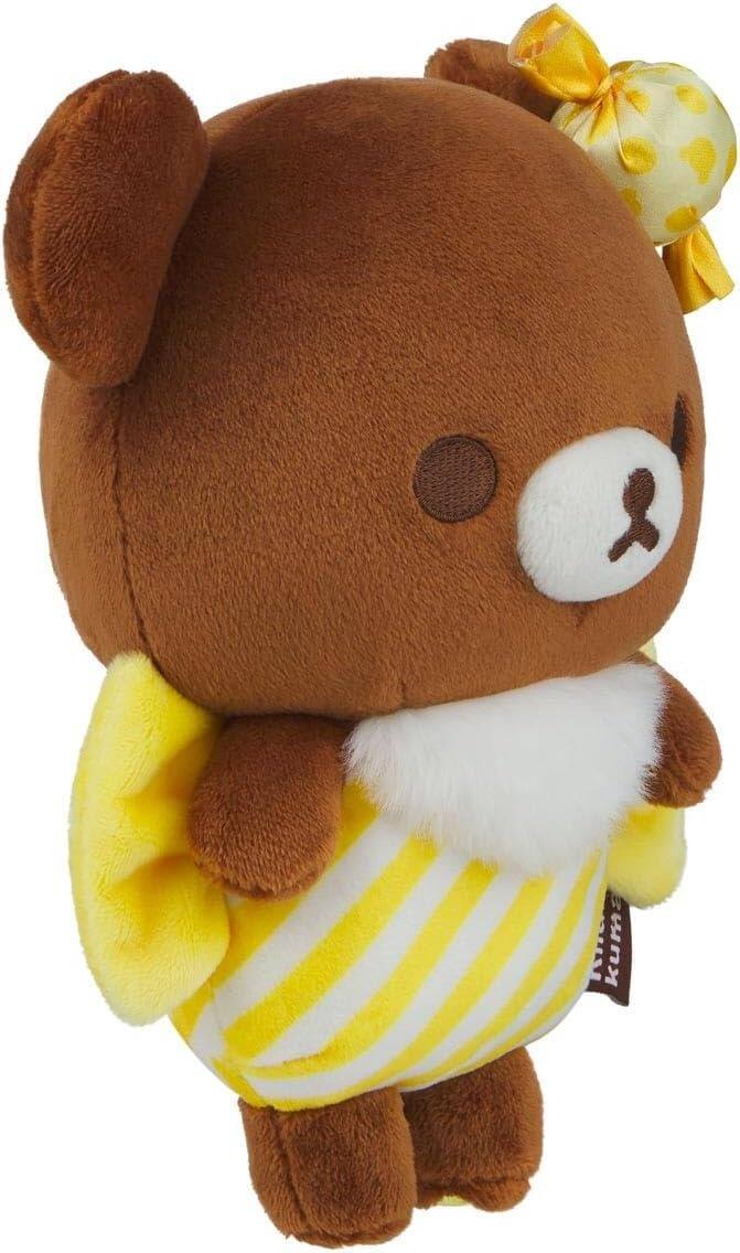 A toy bear with a yellow and white striped outfit and a yellow bow on its head.