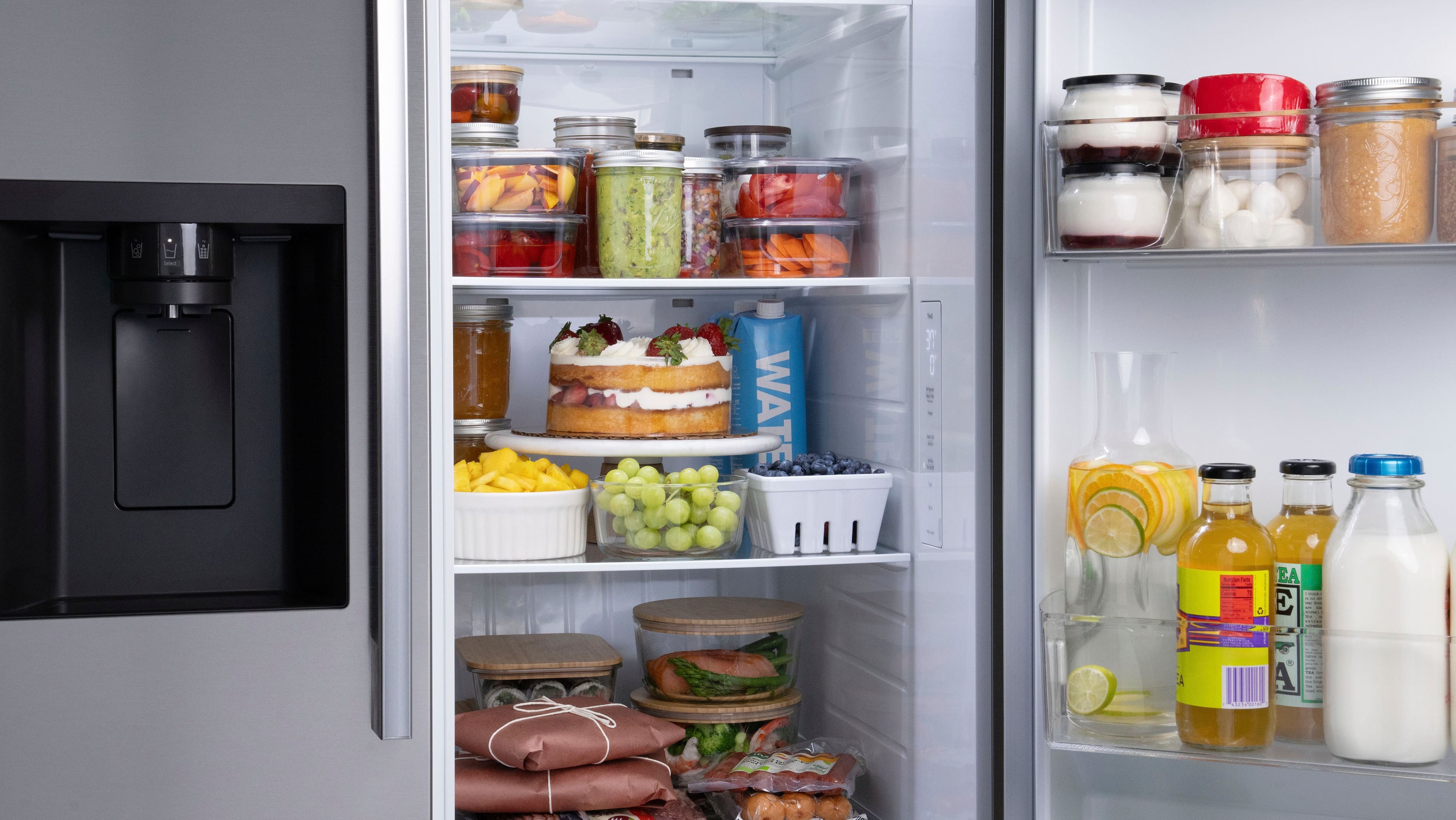 The refrigerator is filled with various food items, including milk, juice, and vegetables. There are also several jars and bottles stored in the fridge. The refrigerator is open, revealing the contents inside.