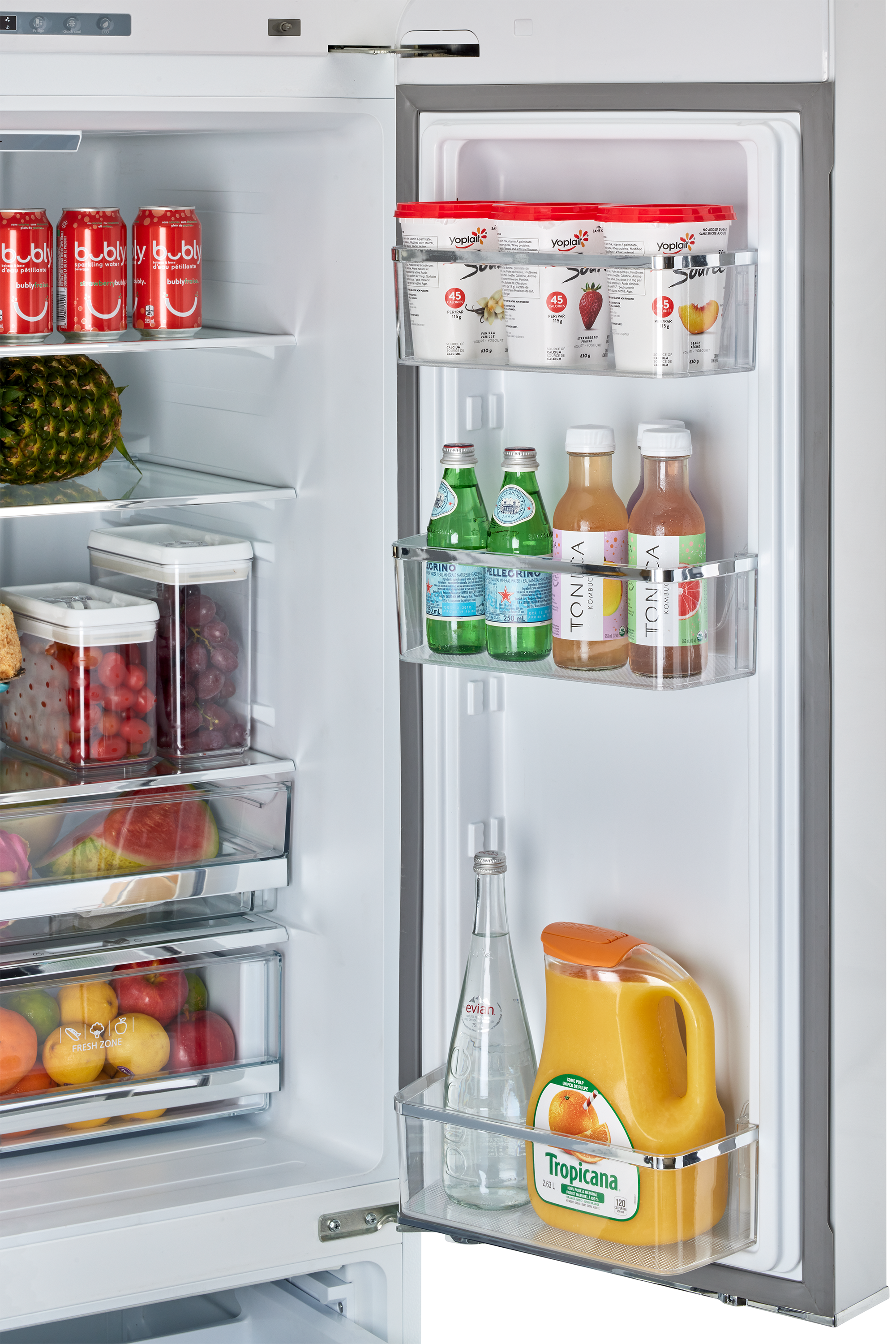 A bottle of bubly beverage sits in the refrigerator, along with a variety of other drinks. There are several bottles of water, juice, and soda, as well as a few cans of soda. The refrigerator is well-stocked with a diverse selection of beverages to choose from.