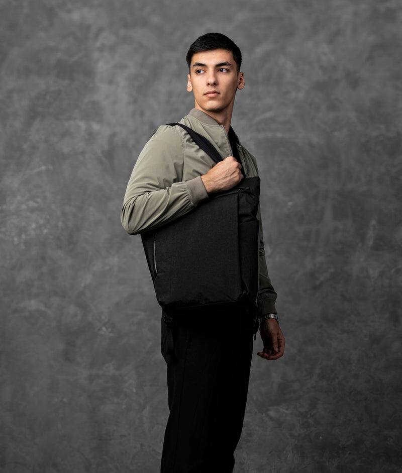 Angle. ALPAKA - Flow Totepack Laptop Backpack for Men, 16" Laptop Compartment + 11" Tablet Sleeve, Tote/Backpack, Bottle Pocket - Black Axoflux 400D Washed Nylon.