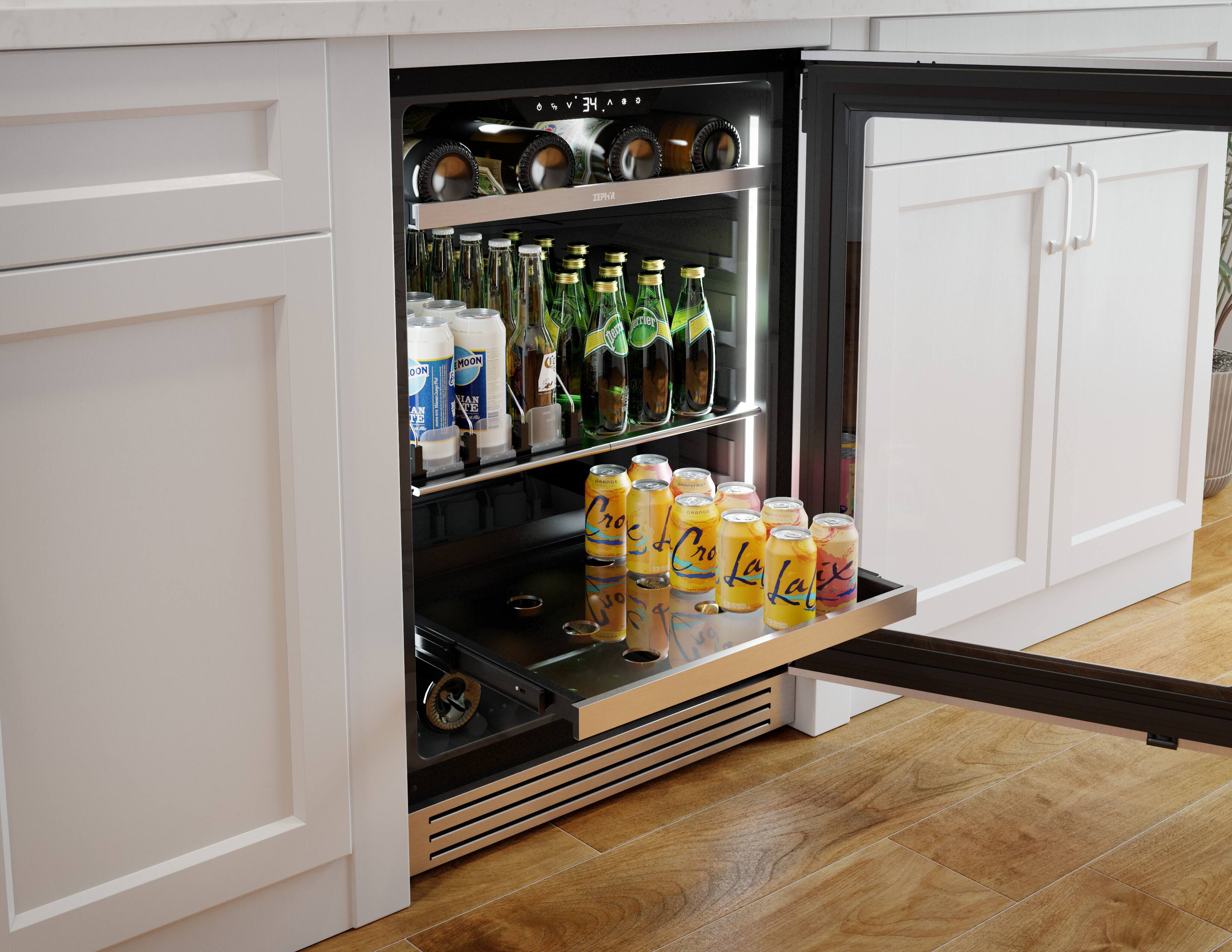 The image shows a refrigerator with a drawer full of drinks, including bottles and cans. The refrigerator is located in a kitchen, and the drawer is open, revealing the various beverages stored inside. The drinks are organized neatly, making it easy for someone to grab a drink from the refrigerator.