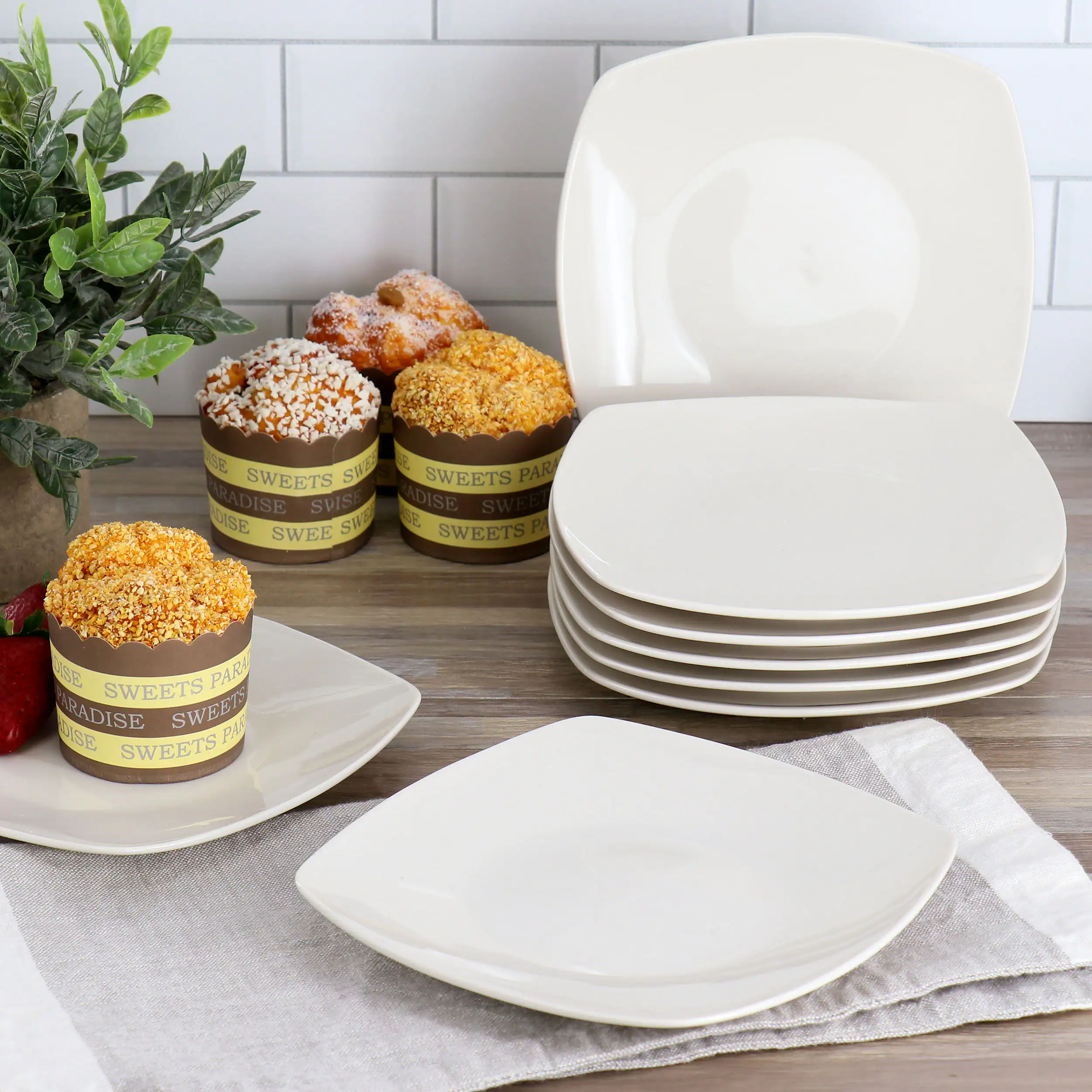 The image shows a table with a variety of food items, including a plate of donuts and a plate of cakes. There are also several bowls on the table, possibly containing more food or desserts. The table setting appears to be for a casual gathering or a small party.