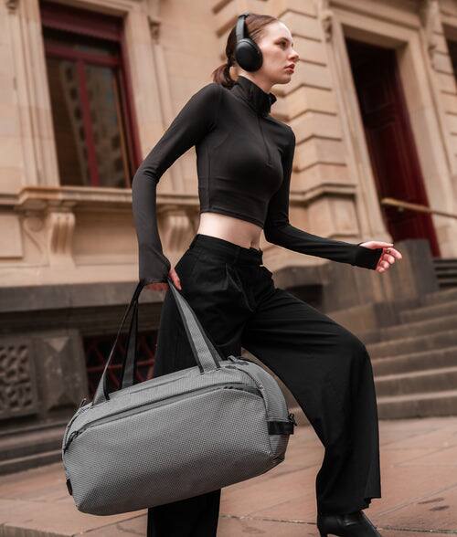 Angle. ALPAKA - 35L Lightweight Duffel Bag for Gym, Weekend Trips & Carry-On Travel, Momentum Duffel, Weather-Resistant - Axodyne hybrid Grey.