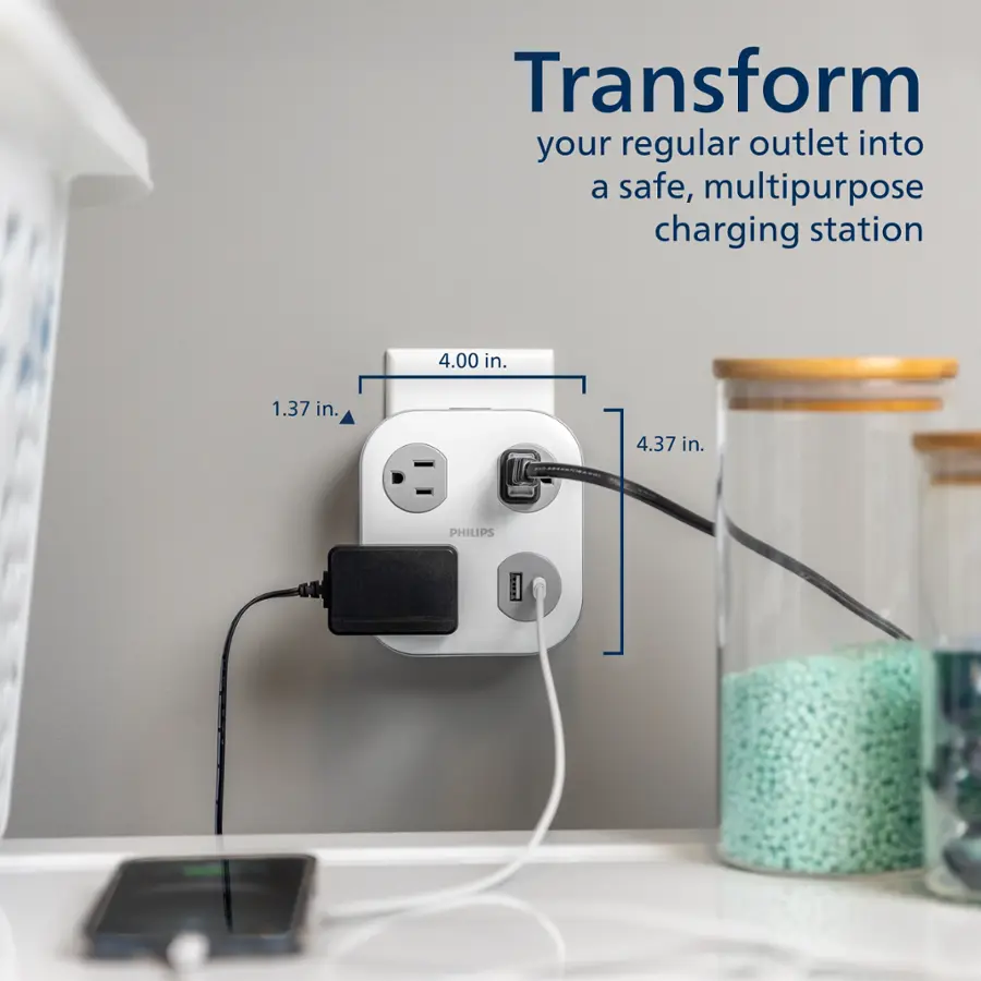 Transform your regular outlet into a safe, multipurpose charging station. The image shows a white power strip with a USB plug and a cell phone plugged into it. The power strip is mounted on the wall, and it is connected to a charging station. The dimensions of the power strip are 4.00 in. by 1.37 in. by 4.37 in.