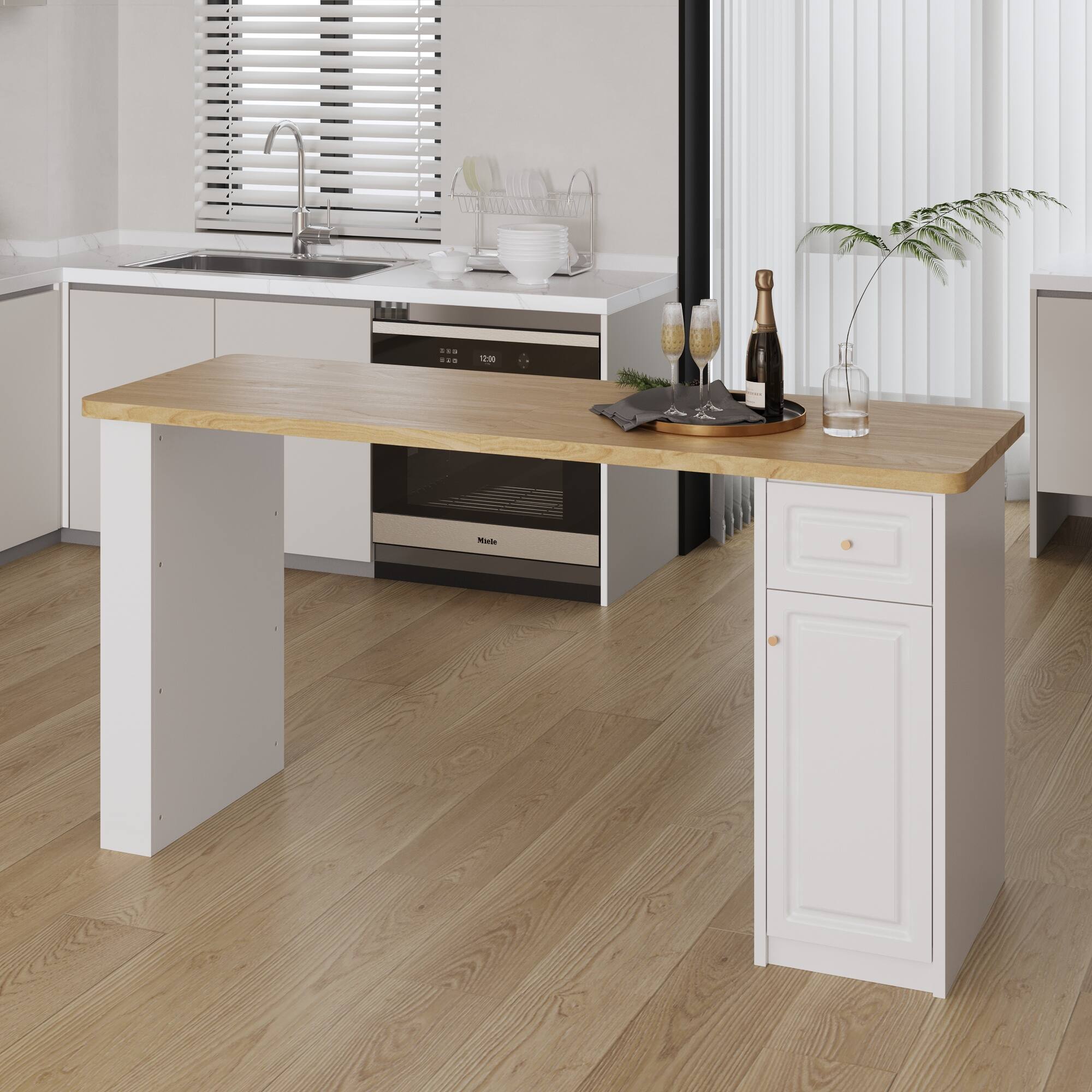 The image shows a modern kitchen with a wooden island. The island has a light wood top and white cabinets with gold handles. On the island, there are two champagne glasses, a bottle of champagne, a glass of water, and a small plant. In the background, there is a sink with a modern faucet, a dish rack with dishes, and an oven with a digital display showing "12:00." The floor is made of light wood, and the walls are white with vertical paneling.