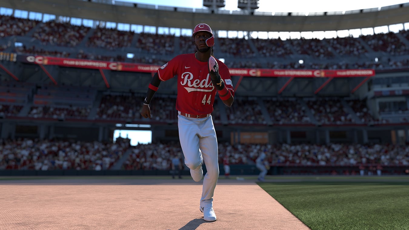 The image shows a baseball player wearing a red jersey with the number 44 on it. The player is standing on a baseball field, possibly in a stadium, and is holding a baseball bat. The player is likely a part of the Cincinnati Reds team.