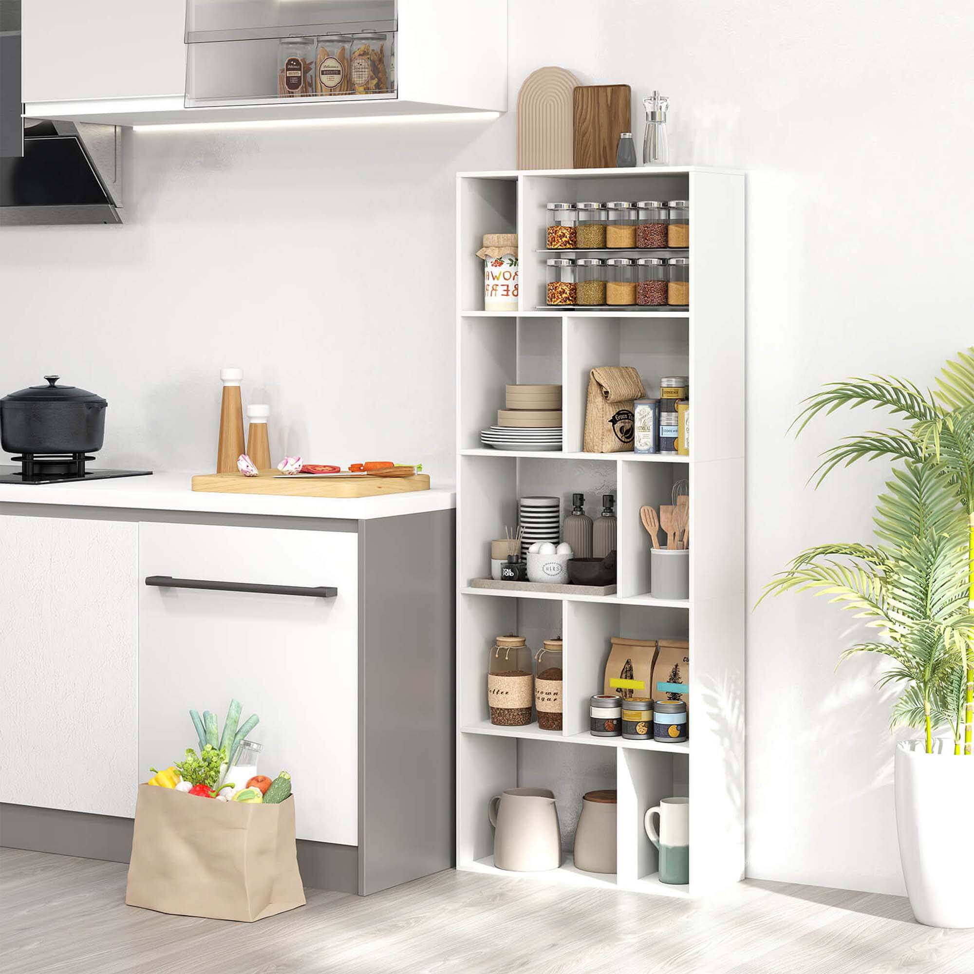 The image shows a kitchen with a counter and a white cabinet. The cabinet has a shelf with various items on it, including several bottles and a bowl. There are also some fruits and vegetables on the counter, such as bananas, apples, and carrots. Additionally, there is a potted plant in the kitchen, adding a touch of greenery to the space.