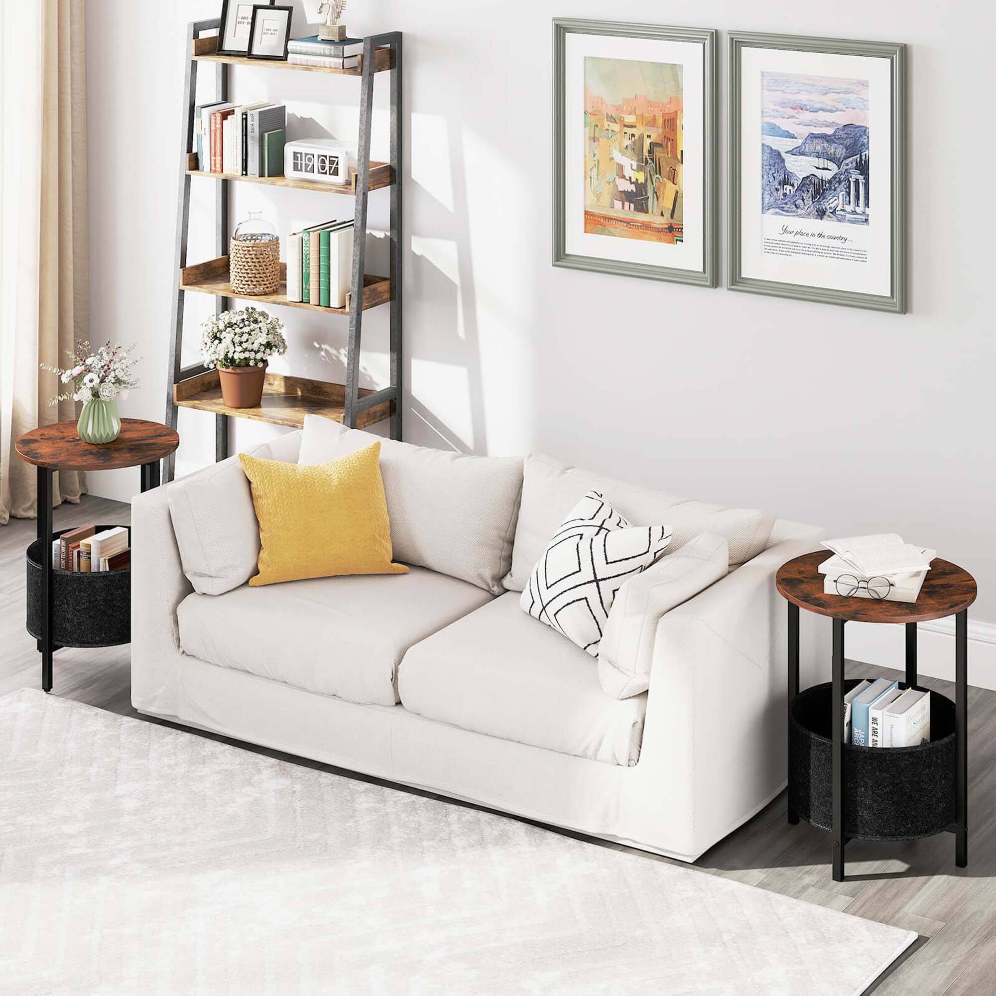 The image shows a living room with a white couch, a bookshelf, and a coffee table. The couch has two pillows and a blanket on it, and there are several books on the bookshelf. The coffee table is placed next to the couch, and there are two vases on it. The room also features a rug on the floor, adding to the cozy atmosphere of the space.