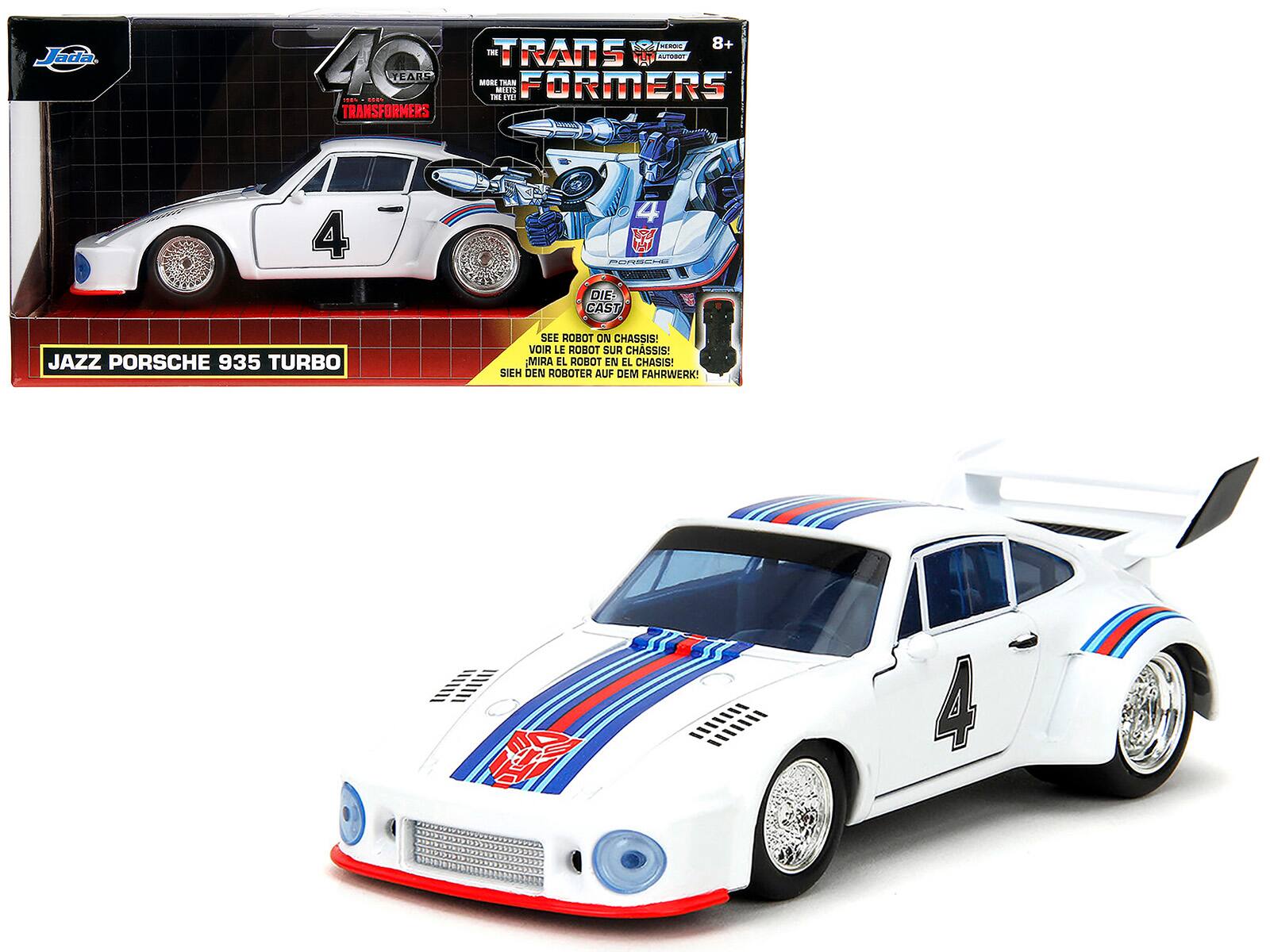 Sure, here is the corrected and grouped text from the image:

---

**Front of the Box:**

- **Jada**
- **40 YEARS TRANSFORMERS**
- **THE TRANSFORMERS**
- **8+**
- **MORE THAN MEETS THE EYE**
- **JAZZ PORSCHE 935 TURBO**
- **SEE ROBOT ON CHASSIS!**
- **VOIR LE ROBOT SUR CHASSIS!**
- **MIRA EL ROBOT EN EL CHASIS!**
- **SIEH DEN ROBOTER AUF DEM FAHRWERK!**

**Side of the Box:**

- **JAZZ PORSCHE 935 TURBO**

---

**Toy Car:**

- **4**
- **PORSCHE**

---