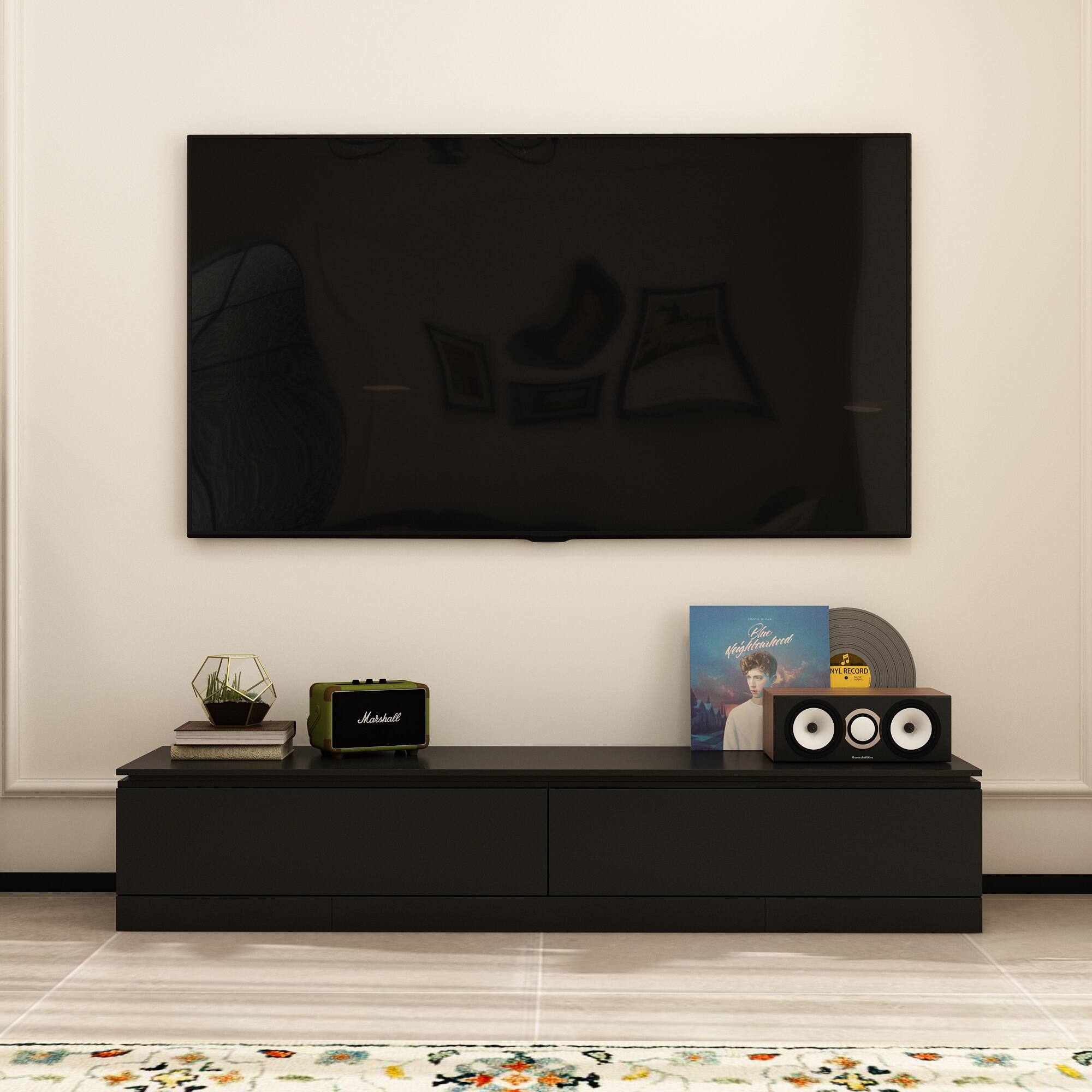 A Wii console sits on a black table in front of a large flat screen TV.