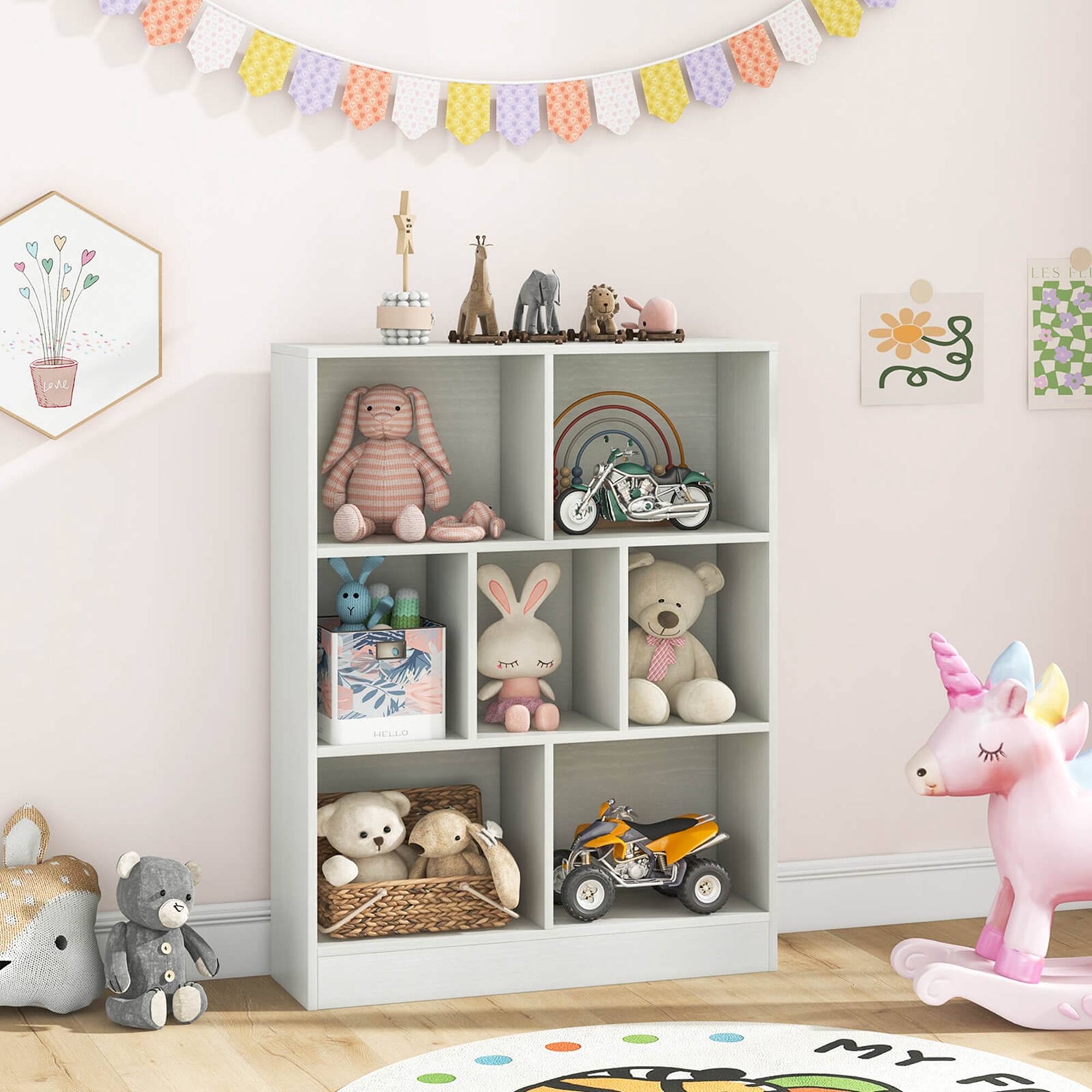 The image features a child's room with a toy shelf filled with various toys, including stuffed animals and a toy car. There are also books on the shelf. The room has a pink wall, and a rainbow decoration is hanging above the shelf. The toy shelf is located near a pink wall and a rainbow decoration.