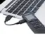 The Olympus N-541PC II camera is connected to a laptop computer. The camera is sitting on top of the laptop, and the USB cable is plugged into the laptop. The camera is likely being used to transfer photos or videos to the laptop.
