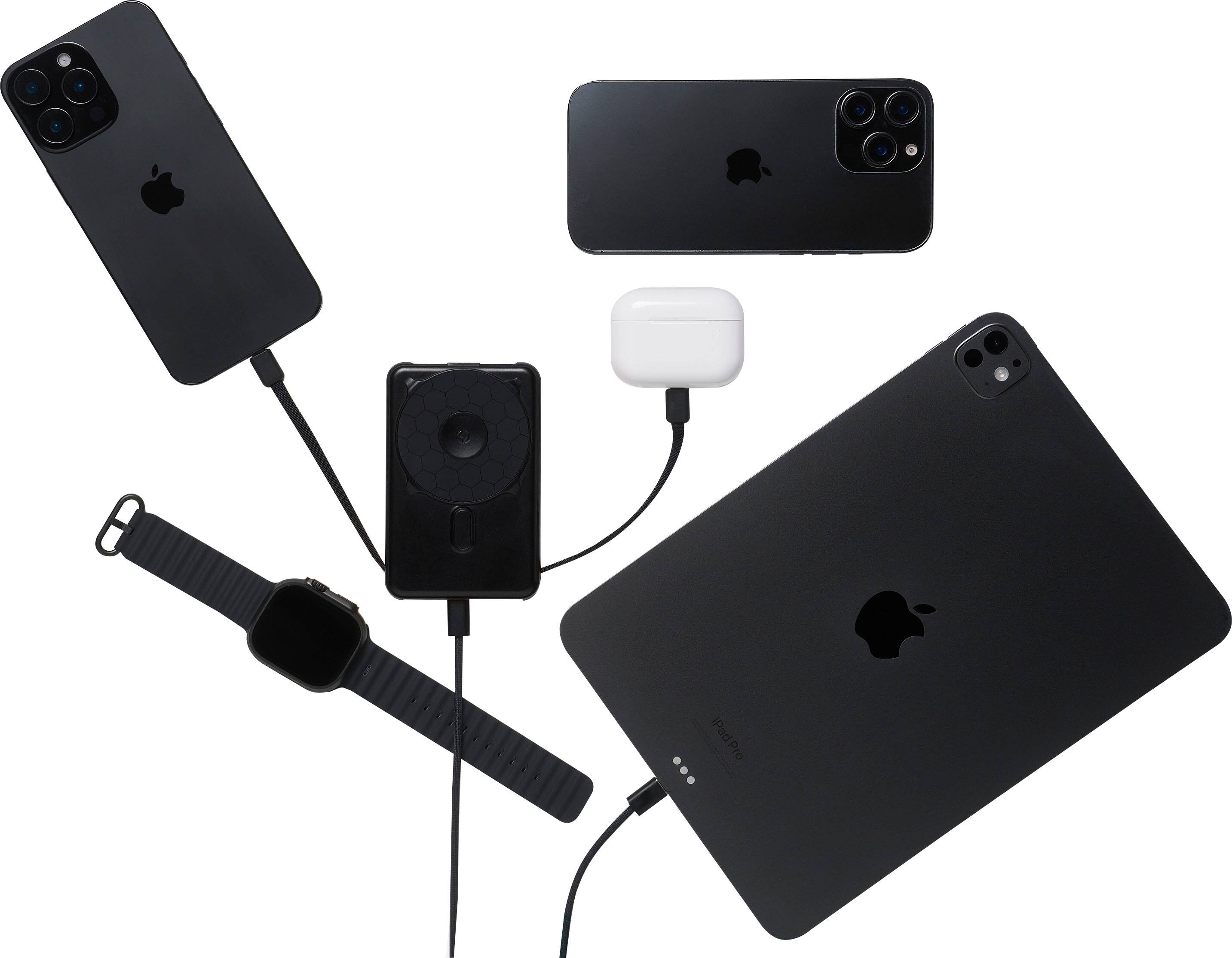 The image shows a collection of various Apple products, including an iPad Pro, a cell phone, a charger, and a watch. The iPad Pro is placed next to the cell phone, while the charger is positioned between them. The watch is located near the top left corner of the image. The arrangement of these items suggests that they are being charged or prepared for use.