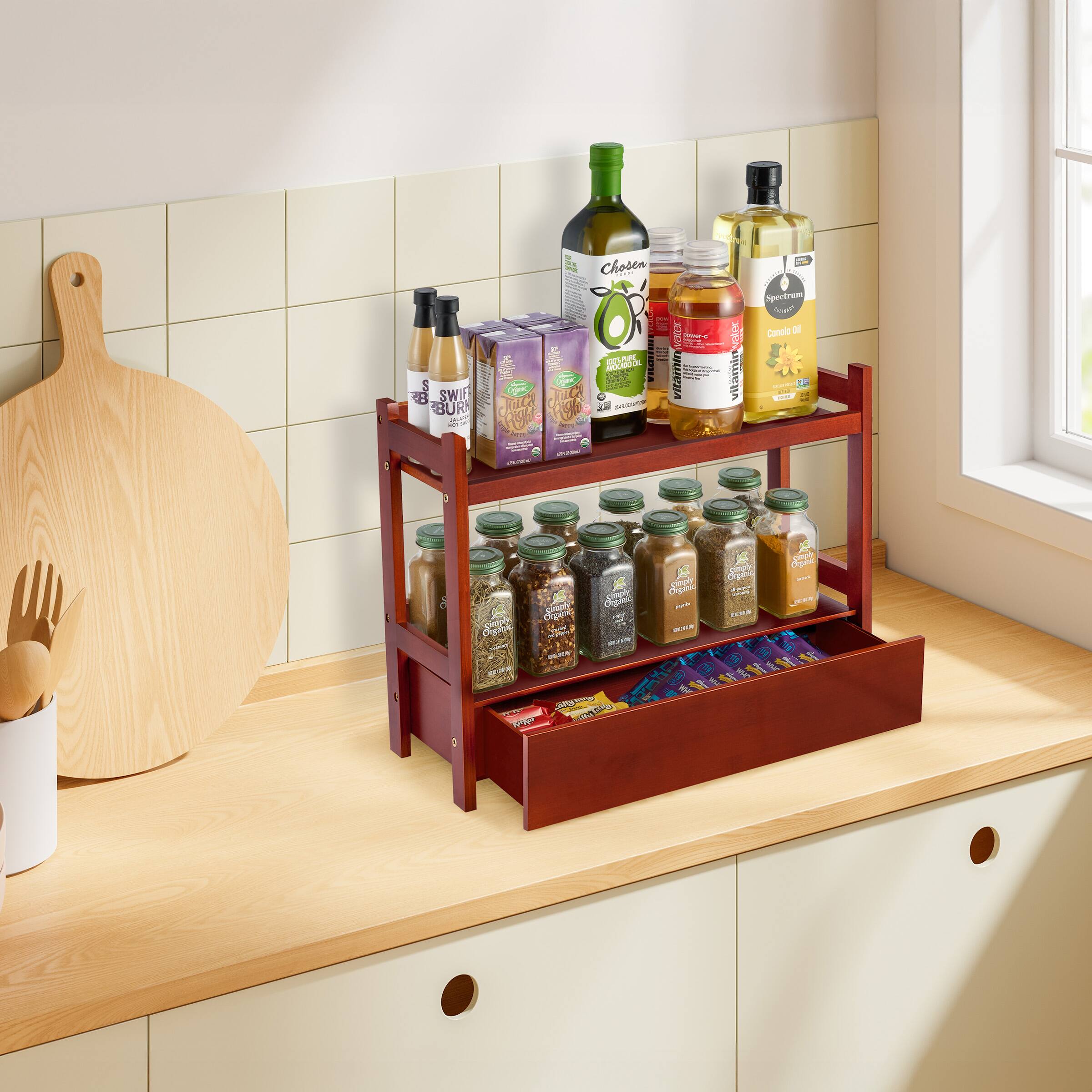 Sure, here is the corrected and grouped text from the image:

- **Top Shelf:**
  - Chosen
  - Spectrum
  - Canelo Oil
  - Vitamin E
  - SWI BUR

- **Middle Shelf:**
  - SWI BUR
  - Chosen
  - Spectrum
  - Canelo Oil
  - Vitamin E

- **Bottom Shelf:**
  - Various spices and herbs (labels not fully readable)

- **Additional Items:**
  - Wooden cutting board
  - Wooden utensils
  - Purple box (text not fully readable)
  - Blue and purple packets (text not fully readable)