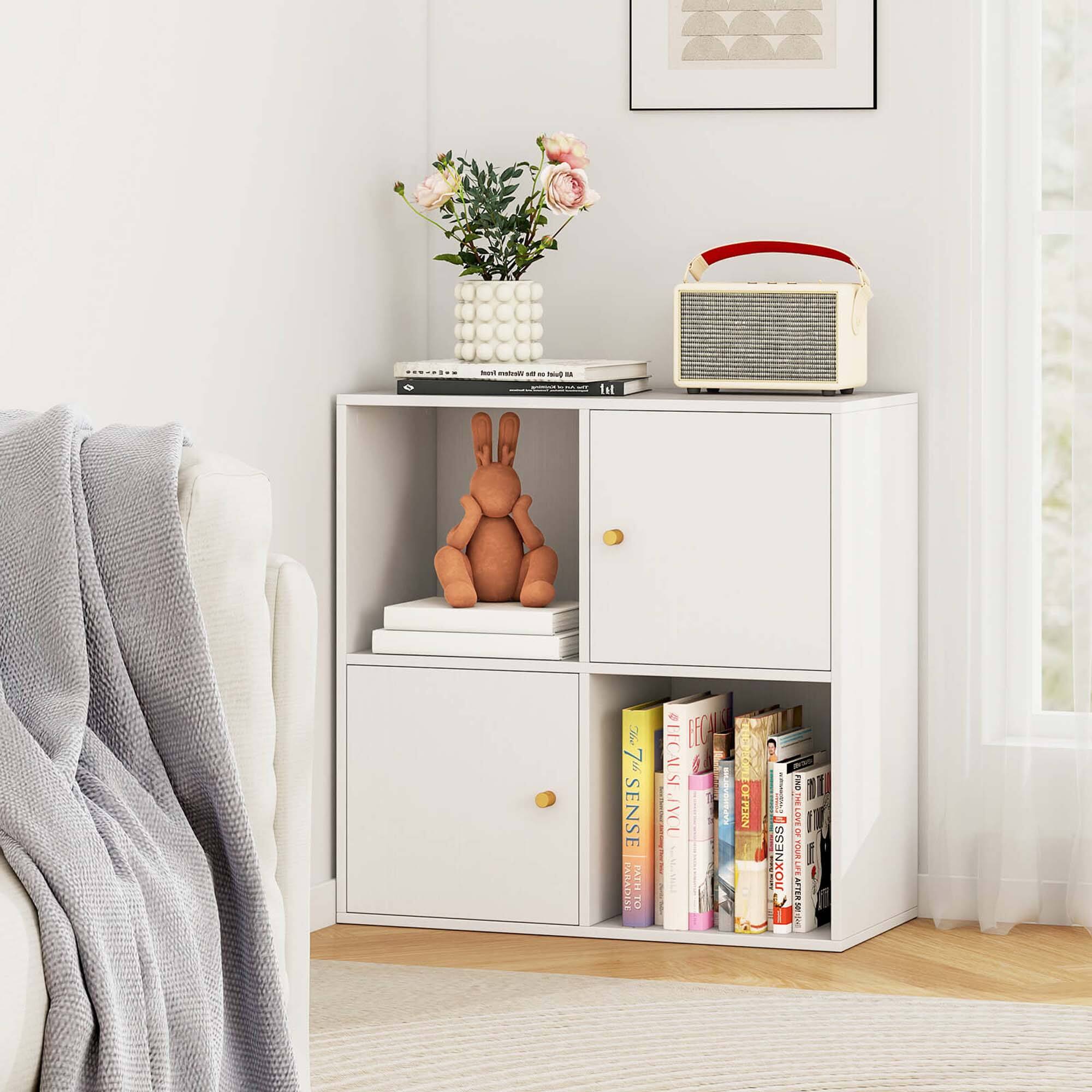 The image features a small white bookshelf with various books, a vase with flowers, and a small bunny figurine. The books are arranged in a neat manner, and the vase with flowers adds a touch of freshness to the scene. The small bunny figurine is placed on top of the bookshelf, adding a playful element to the space. The bookshelf is situated in a living room, and it serves as a functional and decorative piece of furniture.