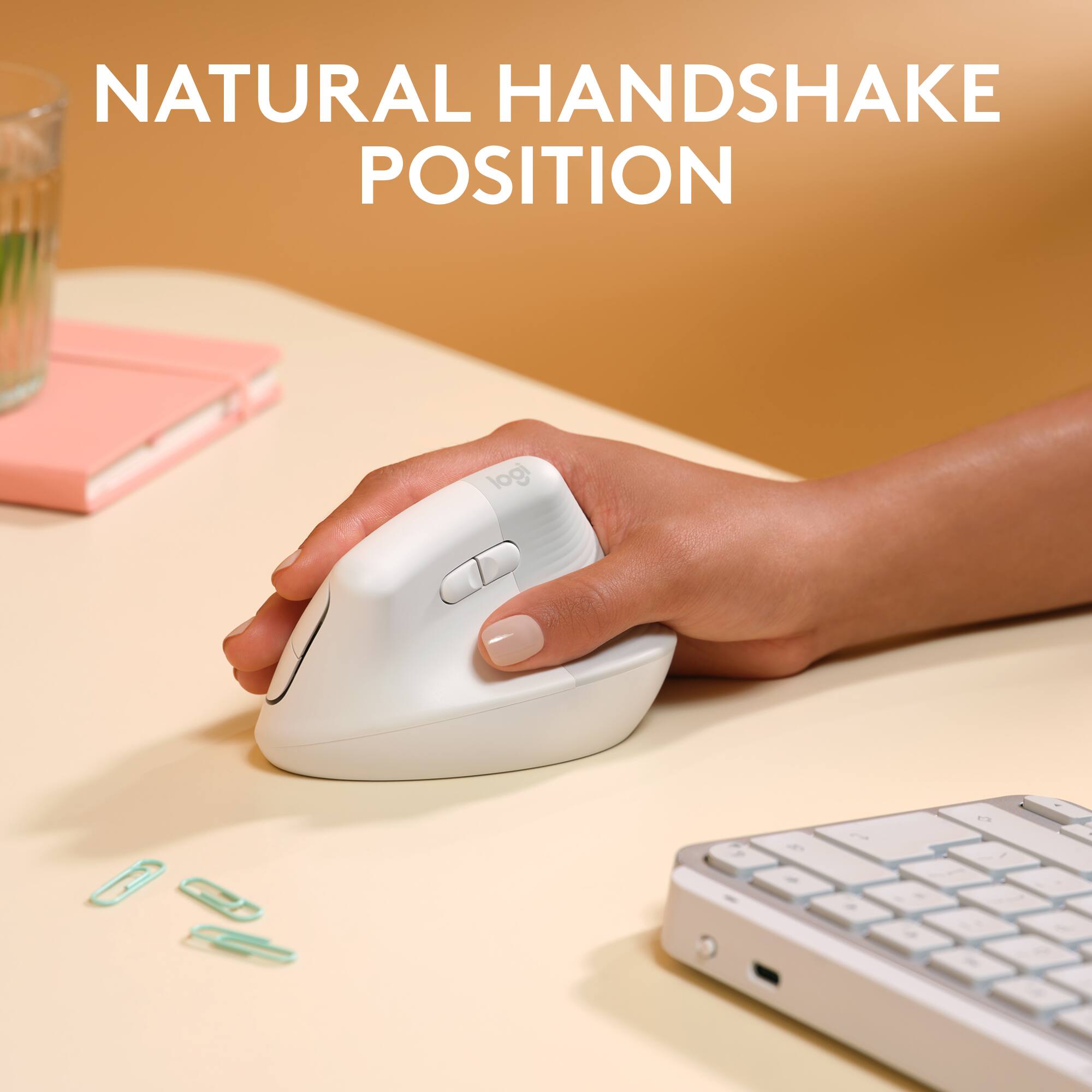NATURAL HANDSHAKE POSITION: A person is using a white Logitech mouse on a table.