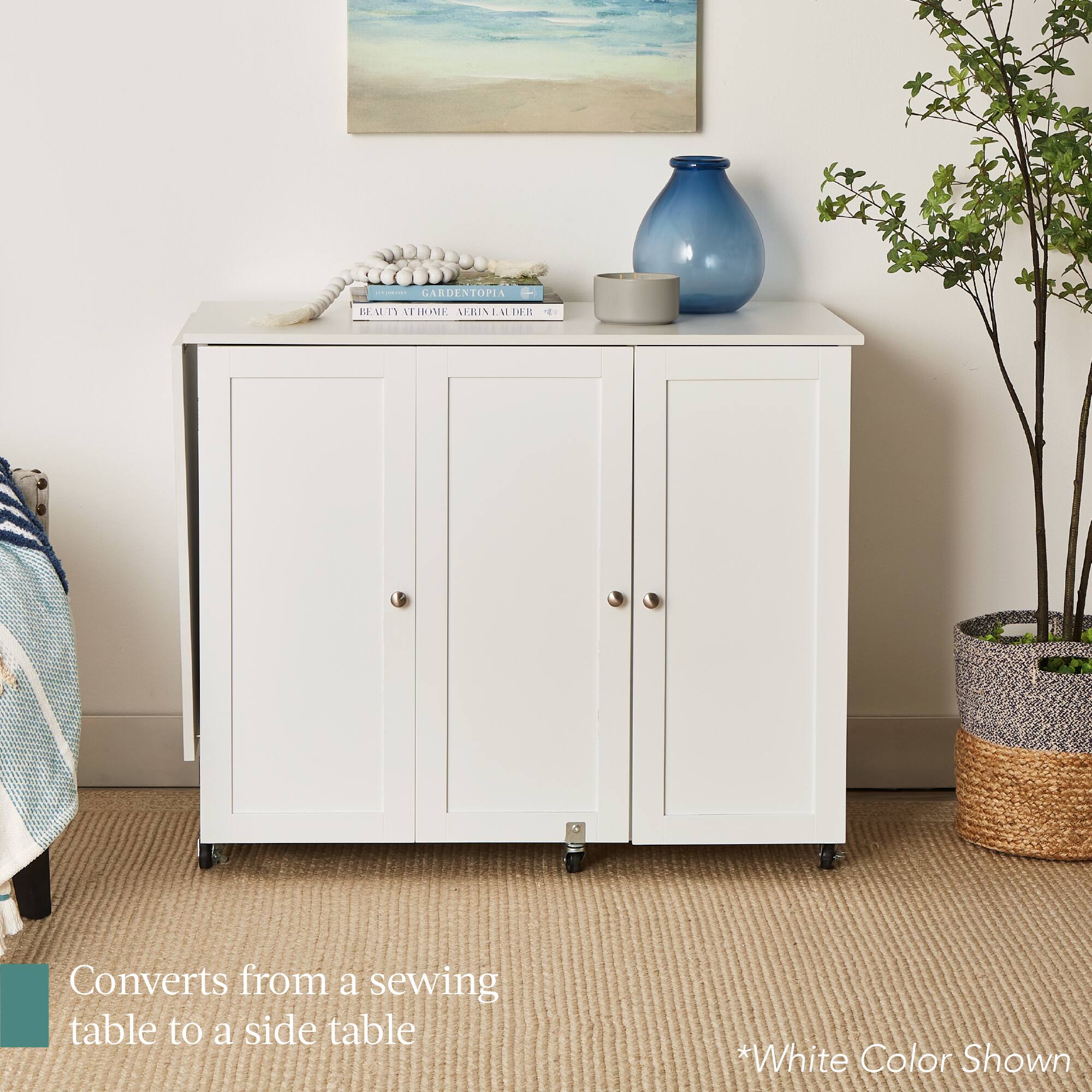 The text on the image reads: "CARDENTOPIA BE.MI Ea VEHOME notiRNEAOR 1HR E Converts from a sewing table to a side table *White Color Shown". 

Corrected and grouped text: "CARDENTOPIA BE.MI Ea VEHOME notiRNEAOR 1HR E - Converts from a sewing table to a side table *White Color Shown".