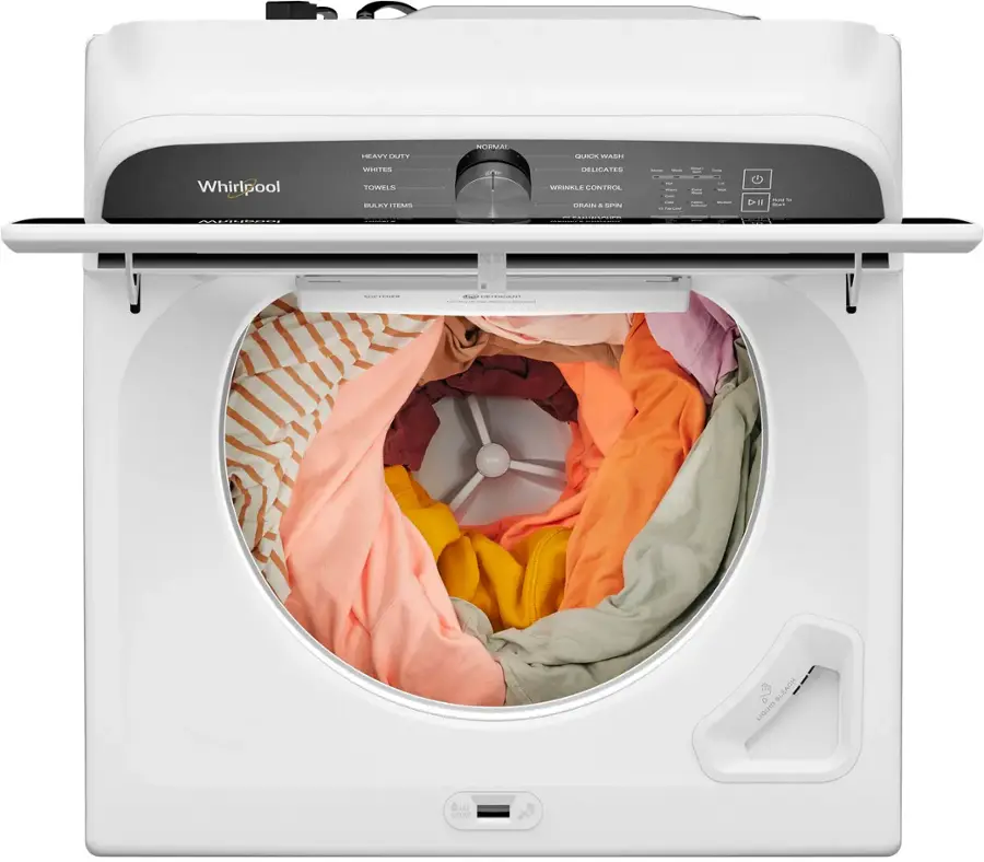 The image features a white Whirlpool washing machine with its door open, revealing a load of laundry inside. The machine is designed to wash clothes, towels, and delicates, and it is equipped with a spin cycle and a liquid bleach dispenser. The machine is likely used in a home setting, as it is a common household appliance for doing laundry.