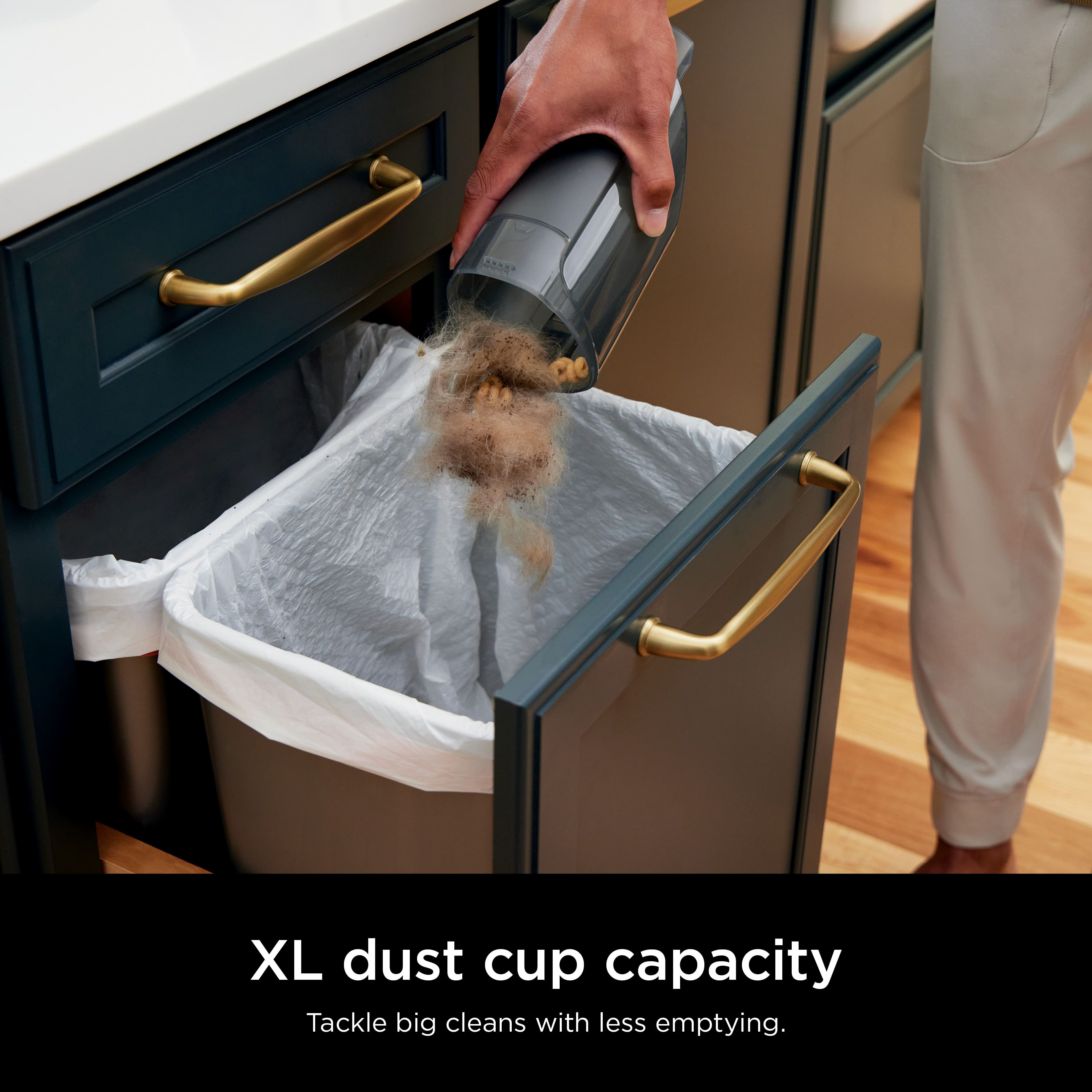 A person is using a dust cup with an XL capacity to tackle big cleaning tasks with less emptying.