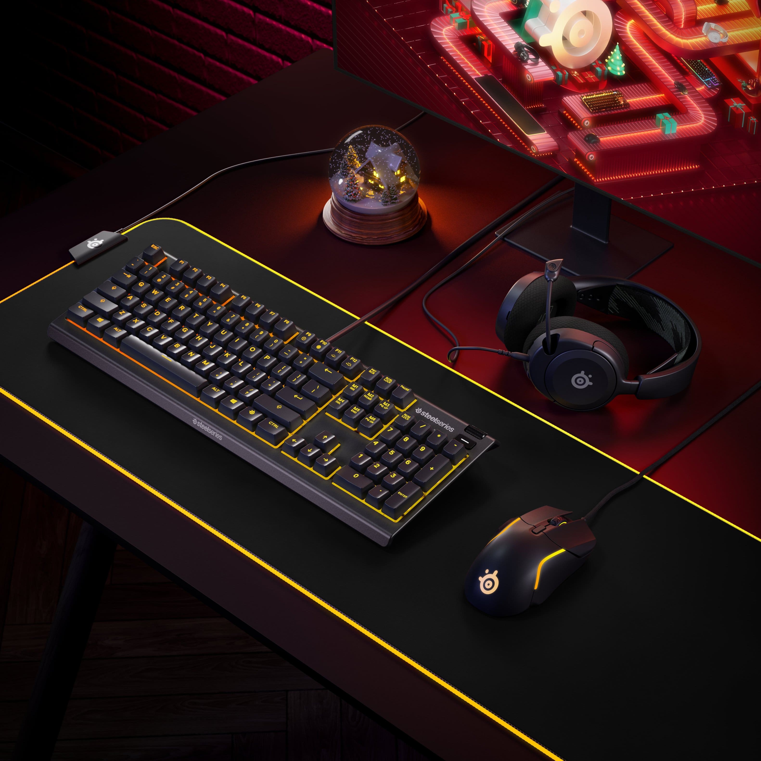 The image features a computer keyboard and mouse on a desk. The keyboard is black and yellow, and it is accompanied by a mouse. The desk also has a pair of headphones on it. The scene is set against a backdrop of a red brick wall.