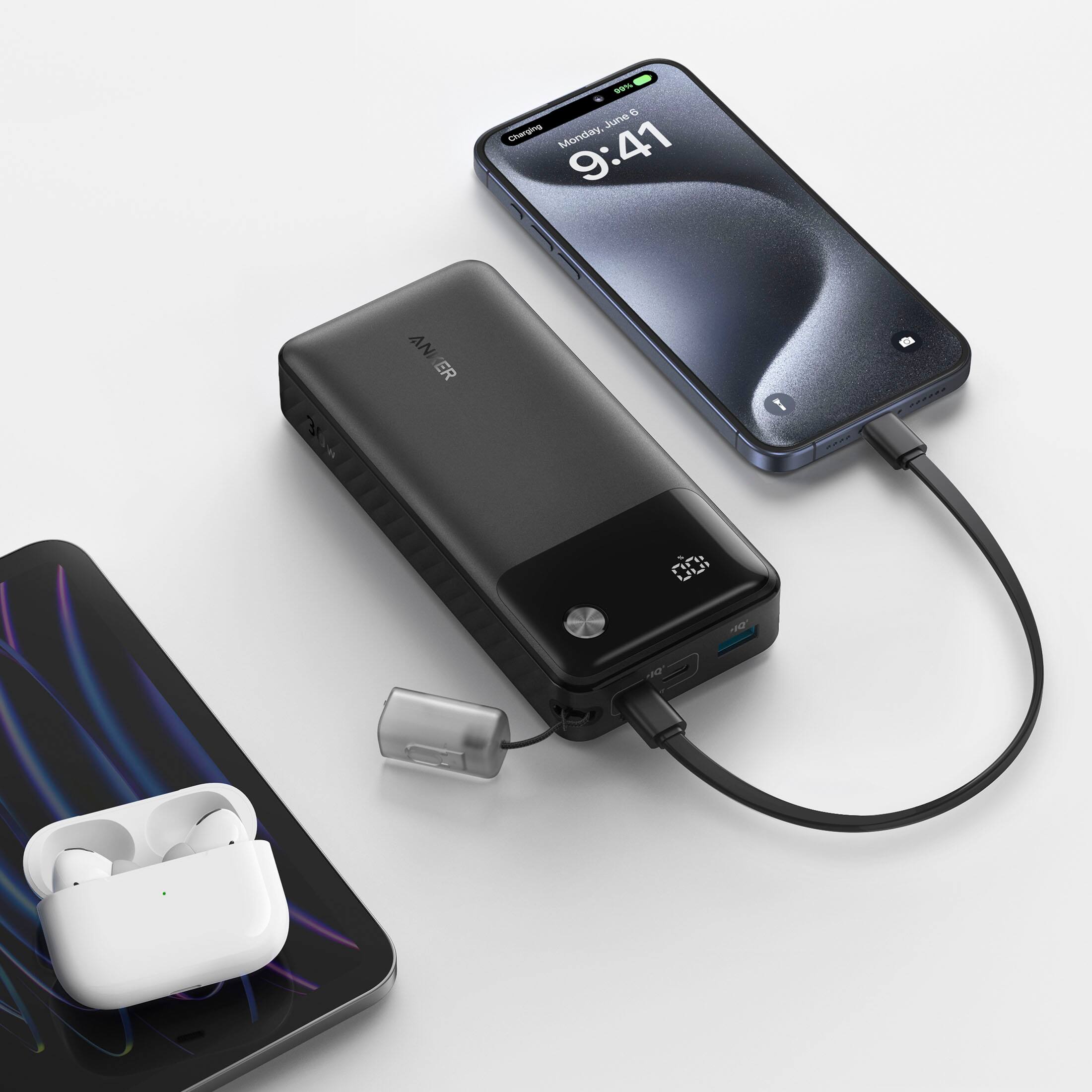 The image shows a cell phone, an earbud, and a charging device. The cell phone is placed next to the earbud and the charging device. The charging device is connected to the cell phone and the earbud, indicating that it is charging them. The time displayed on the cell phone is 9:41.