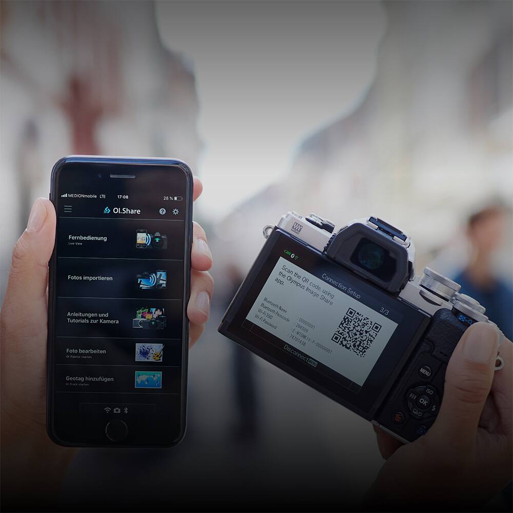 A MEDIONmobile LTE T7:08 28%  
OL.Share  
Fernbedienung  
Live View  
Fotos importieren  
Anleitungen und Tutorials zur Kamera  
Foto bearbeiten  
Geotag hinzufügen  

Scan the Olympus OR Connection code using the Olympus Image Share app.  
Image using Setup  
Bluetooth  
Some  
15  
Fasszade  
Password: 244509  
00000001  
74705435  
E-M10M 2  
Disconnect  
10000000  
CN 3/3  
MENU  
ISO  
EF  
OK  
5  

Connection Setup  
Scan the Olympus OR Connection code using the Olympus Image Share app.  
Bluetooth  
WiFi  
Password: 244509  
00000001  
74705435  
E-M10M 2  
Disconnect  
10000000  
CN 3/3  
MENU  
ISO  
EF  
OK  
5