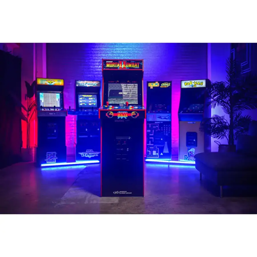 The image features a room with a collection of old-fashioned video game machines, including a Mortal Kombat machine and a Pac-Man machine. The machines are arranged in a row, with some of them being lit up by neon lights. The room also contains a couch and a potted plant, creating a cozy and nostalgic atmosphere.