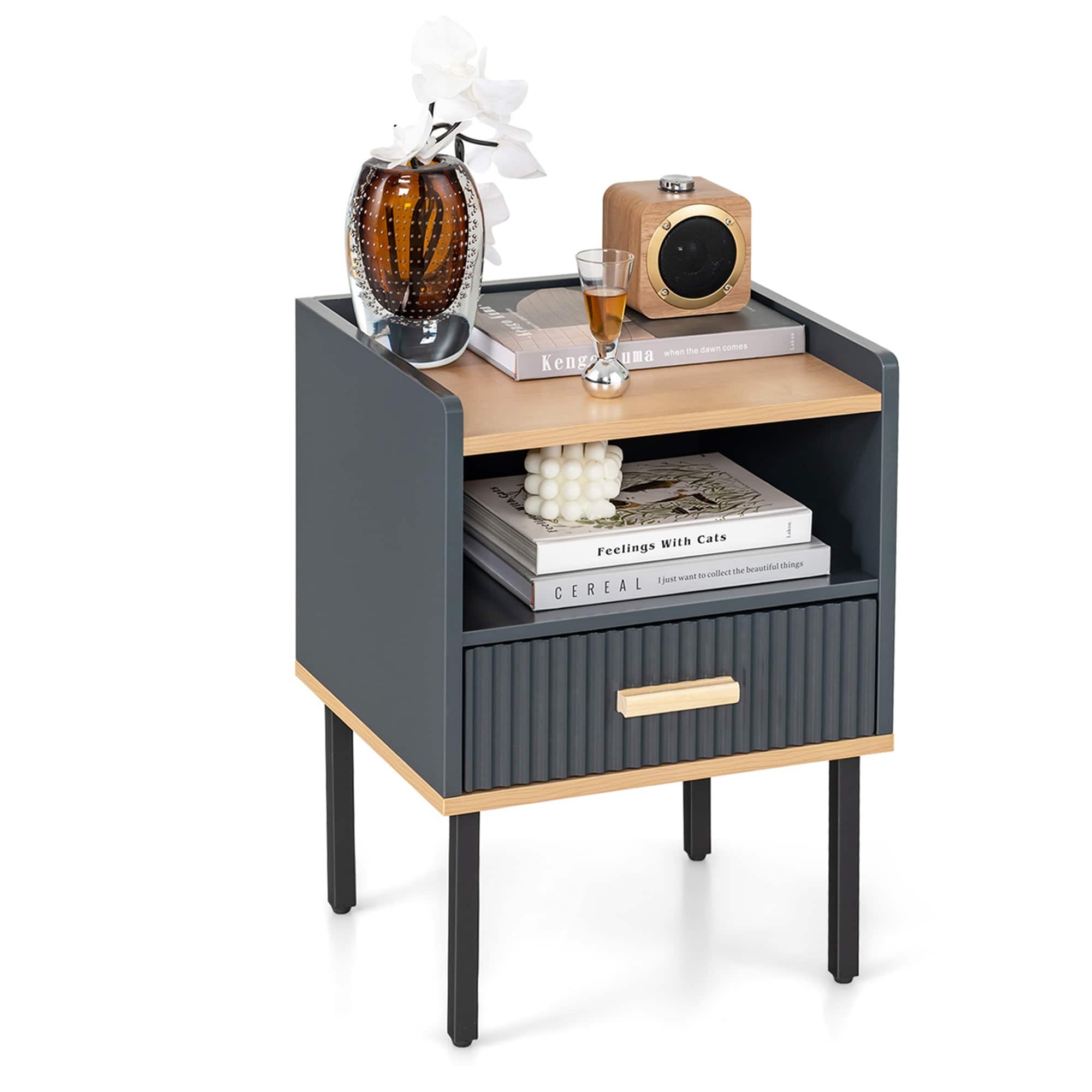 The image features a small table with a variety of items on it. There is a vase with flowers, a glass of wine, a radio, and several books. The table also has a drawer with a white ball inside it. The arrangement of these items creates an aesthetically pleasing and functional display.