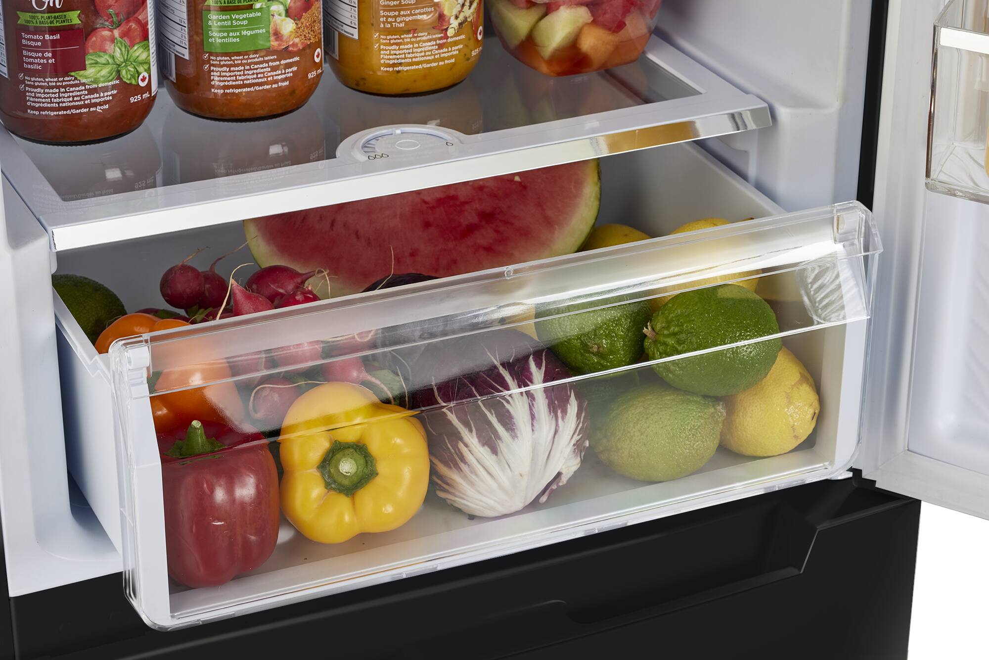 The image shows an open refrigerator filled with a variety of fruits and vegetables. The contents include apples, oranges, and a variety of other produce. The refrigerator is stocked with a diverse assortment of items, making it a well-rounded and healthy selection of food.