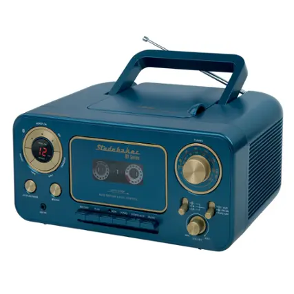 The image features a blue Studebaker radio with a gold faceplate. The radio has a clock on the left side and a tuning knob on the right side. The radio also has a record player with a pause button, a play button, and a stop button. The radio is turned on and ready to play.