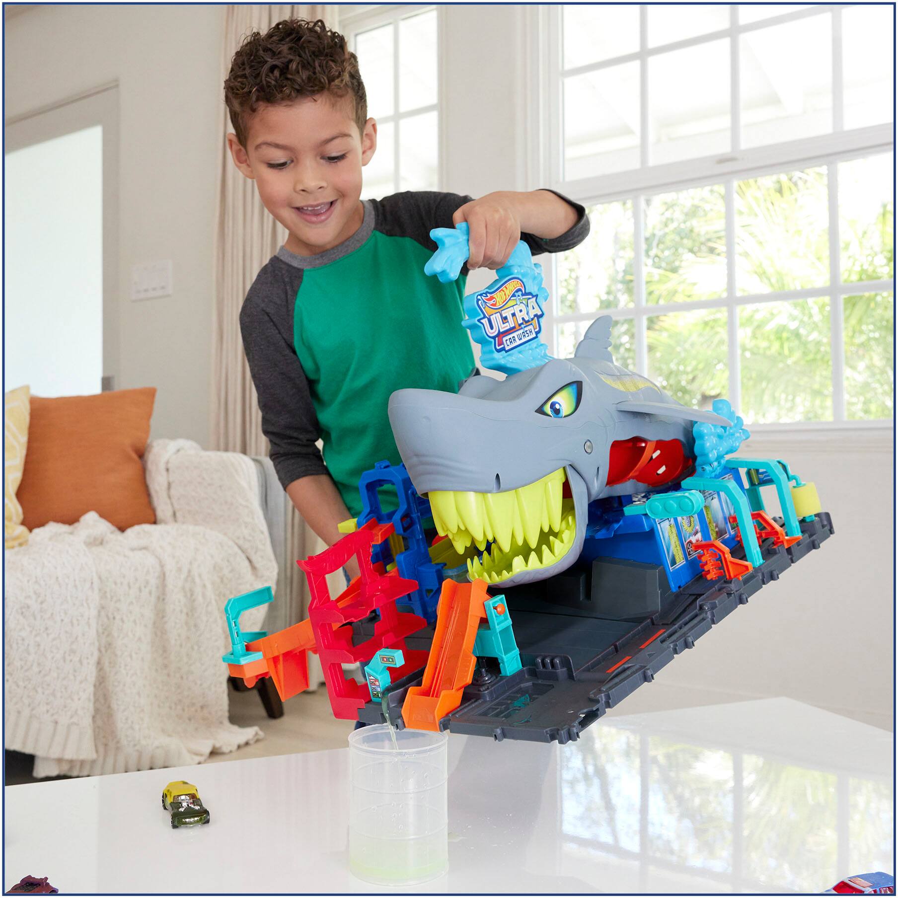 Ultra Pa Car is a toy that the young boy is playing with. He is pouring a liquid into the toy, which is a car.