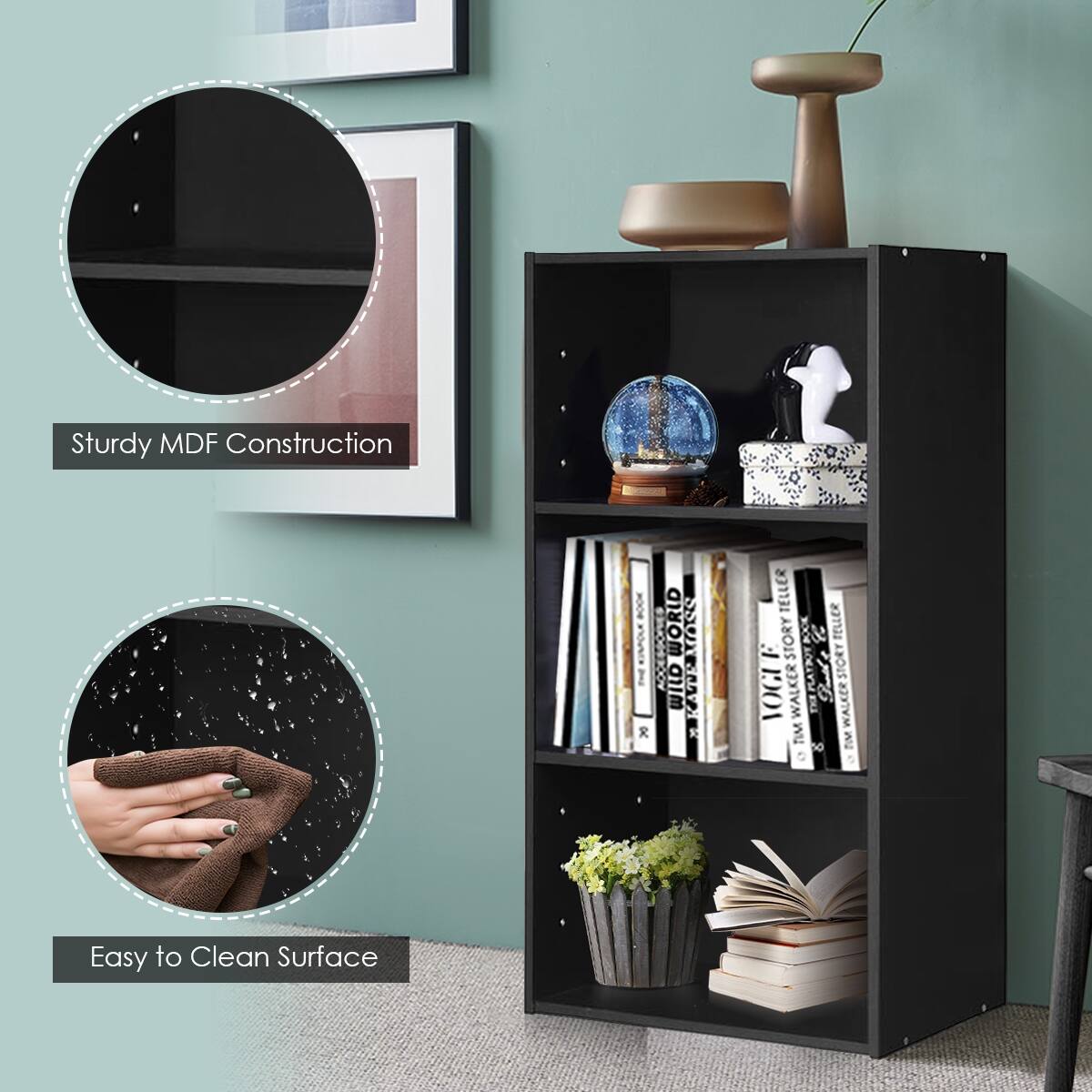 The image features a black bookshelf with a variety of books and decorative items. The shelf is made of sturdy MDF construction, and it has a clean surface that is easy to clean. The bookshelf is filled with books, including a book titled "The Adhesive World." Additionally, there are several decorative items on the shelf, such as a vase, a potted plant, and a clock. The bookshelf is placed in a room with a green wall, and there is a person visible in the background.