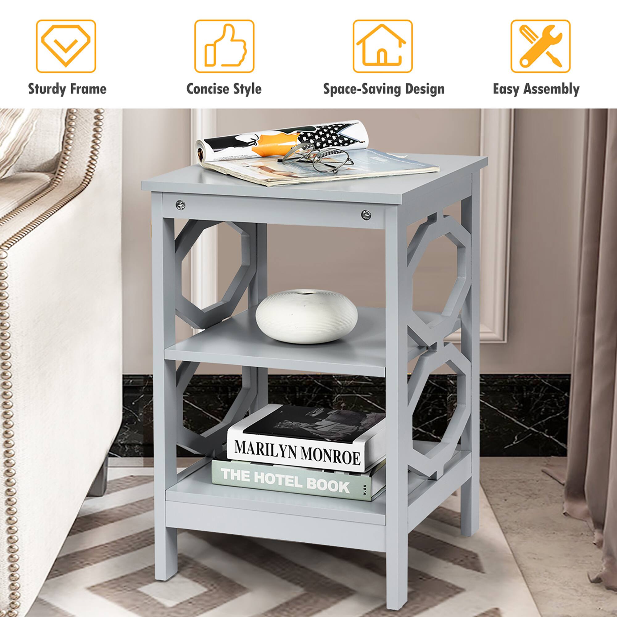 The image features a small table with a shelf on it. The table has a sturdy frame and a concise style, making it a space-saving design. The table is easy to assemble, and it has a book on it, specifically "The Hotel Book" by Marilyn Monroe.