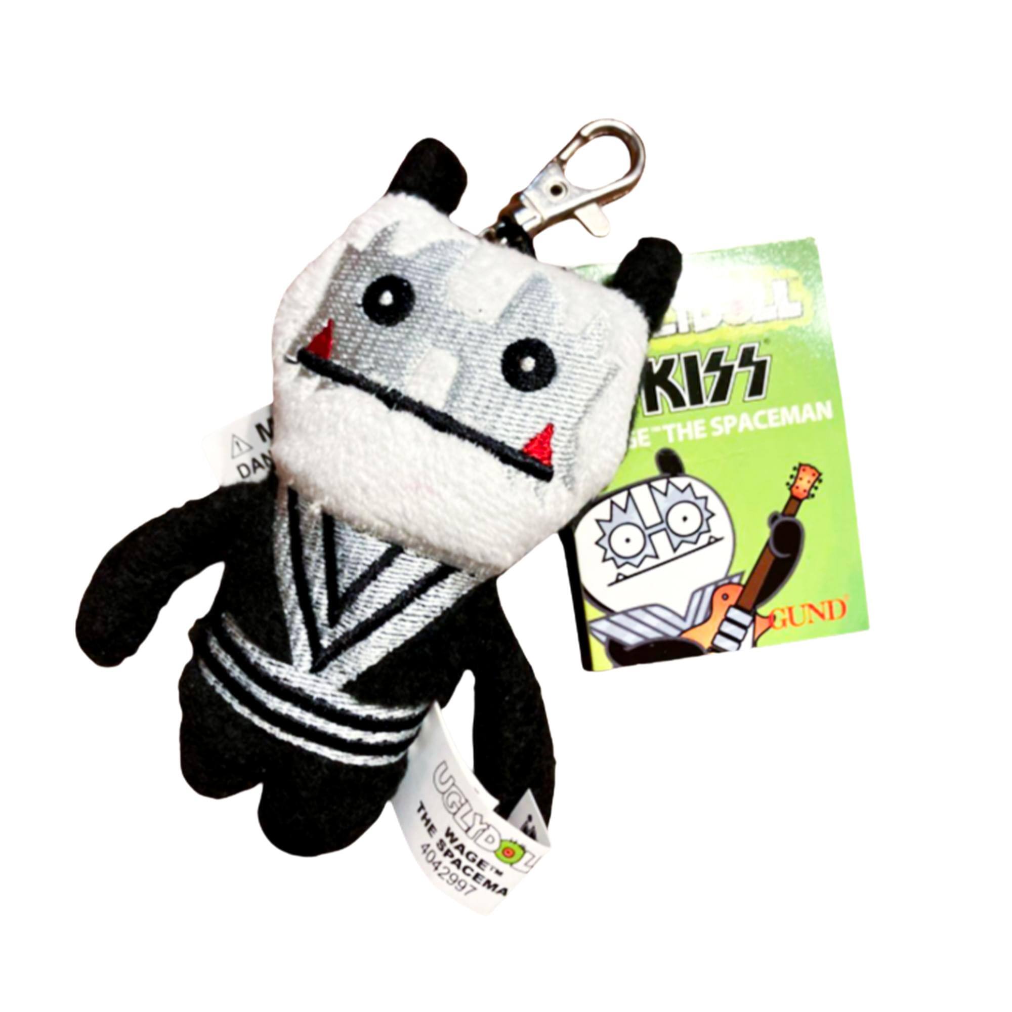 Sure, here is the corrected and grouped text from the image:

**Keychain:**
- UGLYDOLL
- THE SPACEMAN
- 4042997

**Card:**
- UGLYDOLL
- KISS
- "THE SPACEMAN"
- GUND

**Tag:**
- UGLYDOLL
- THE SPACEMAN
- 4042997
