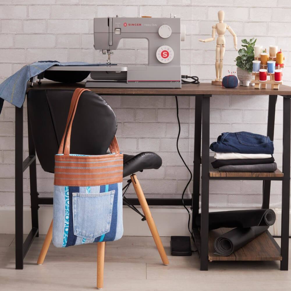 1. SINGER Sewing Machine
2. Heavy Duty
3. SINGER
4. Sewing Machine
5. Fabric and Thread Supplies
6. Mannequin
7. Tote Bag with Denim and Leather Straps
8. Folded Clothes
9. Rugs