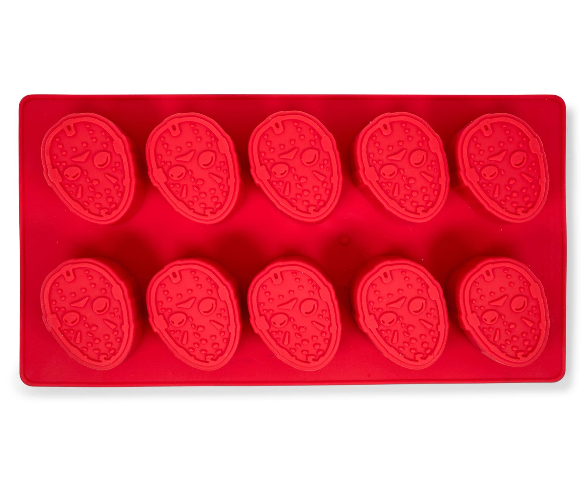 The image shows a red silicone mold with nine cavities, each shaped like a face with eyes, a nose, and a mouth, surrounded by small dots. There is no text on the image.