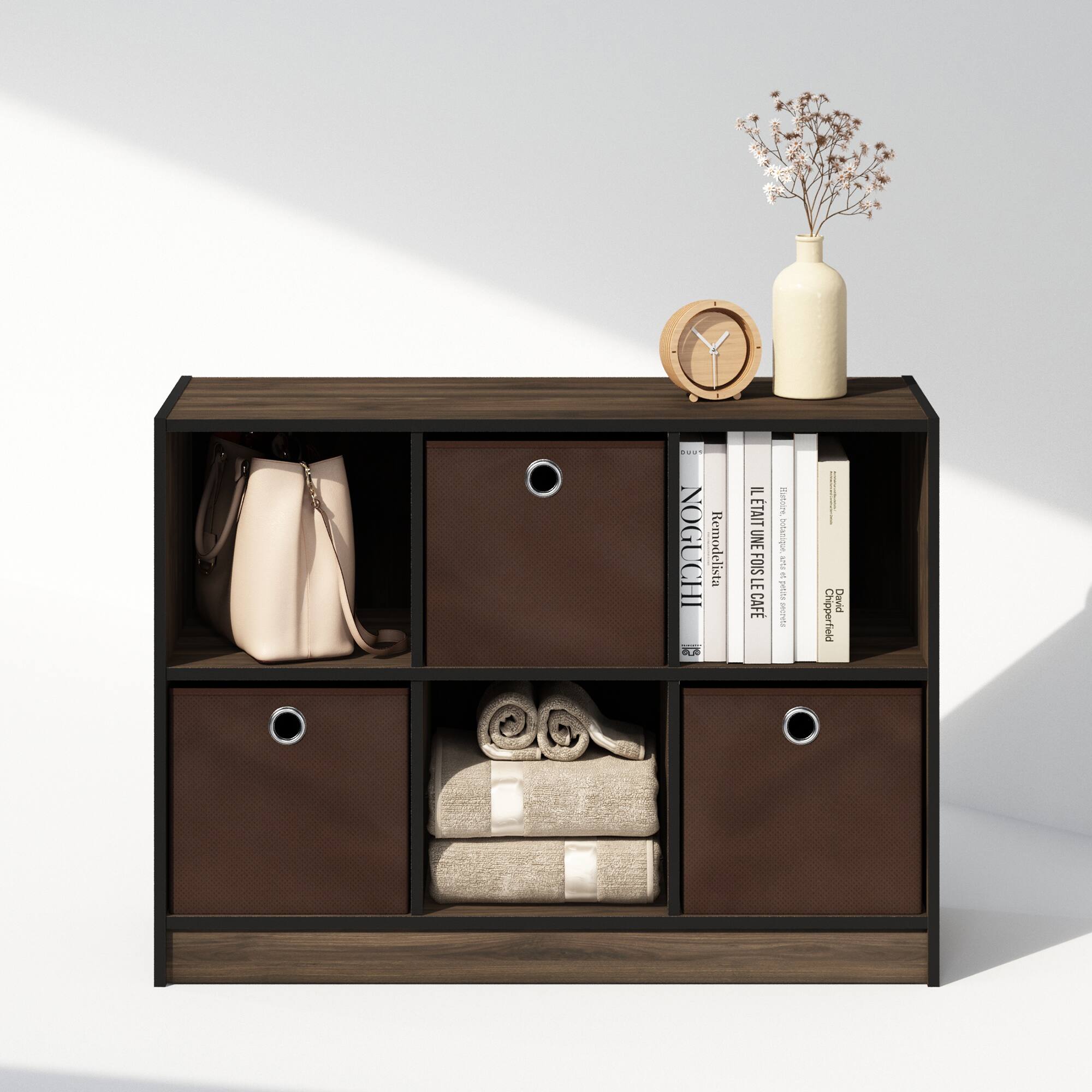 Sure, here is the corrected and grouped text from the image:

**Top Shelf:**
- NOGUCHI Remodelista
- LEONARD LEONARD
- LEONARD LEONARD
- DUCHESSA
- FUIS LE CAFÉ
- David Chipperfield

**Middle Shelf:**
- (No visible text)

**Bottom Shelf:**
- (No visible text)

**Additional Items:**
- (No visible text on the clock or vase)