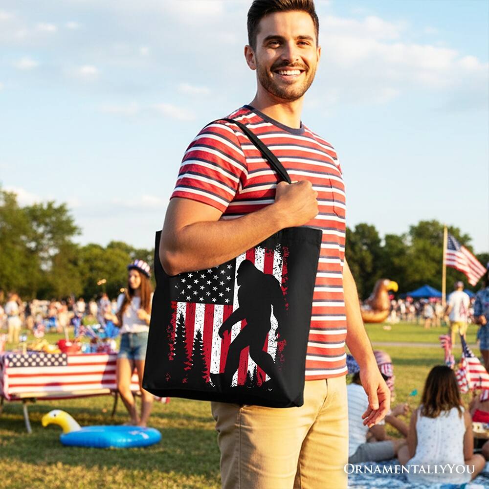 Left. OrnamentallyYou - Bigfoot American Flag Canvas Tote Bag, Patriotic Sasquatch Gift Shopper - Black.
